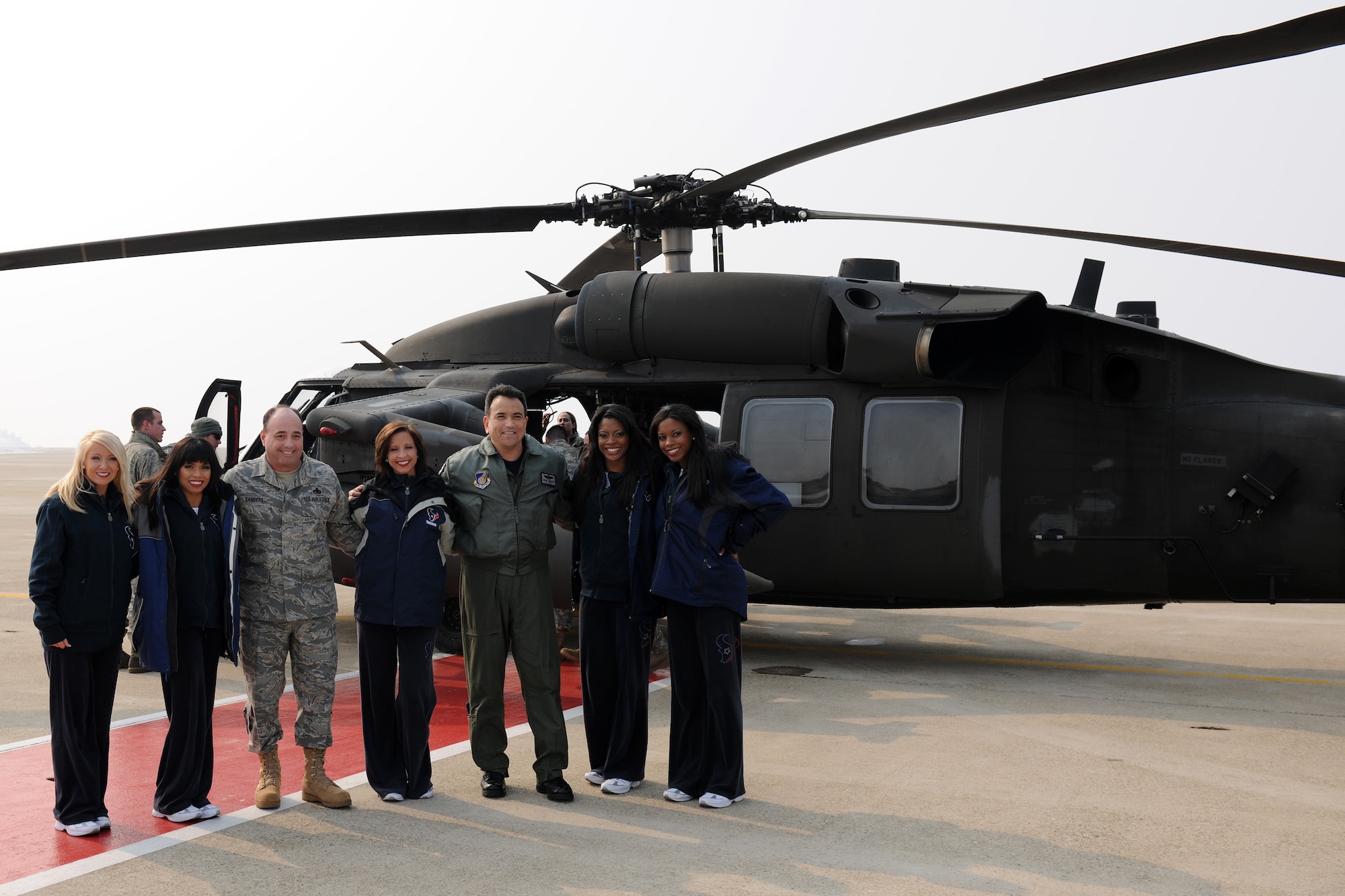 KUNSAN AIR BASE, Republic of Korea --  Cheerleaders representing the National Football League's Houston Texans pose for a photo with Col. Hugh Hanlon, 8th Fighter Wing vice commander and Chief Master Sgt. James Sanders, 8th FW command chief, shortly after arriving on base via helicopter Feb. 3.  During their stay, the cheerleaders signed autographs and posed for pictures with Wolf Pack Airmen.(U.S. Air Force photo/Tech. Sgt. Jonathan Pomeroy)