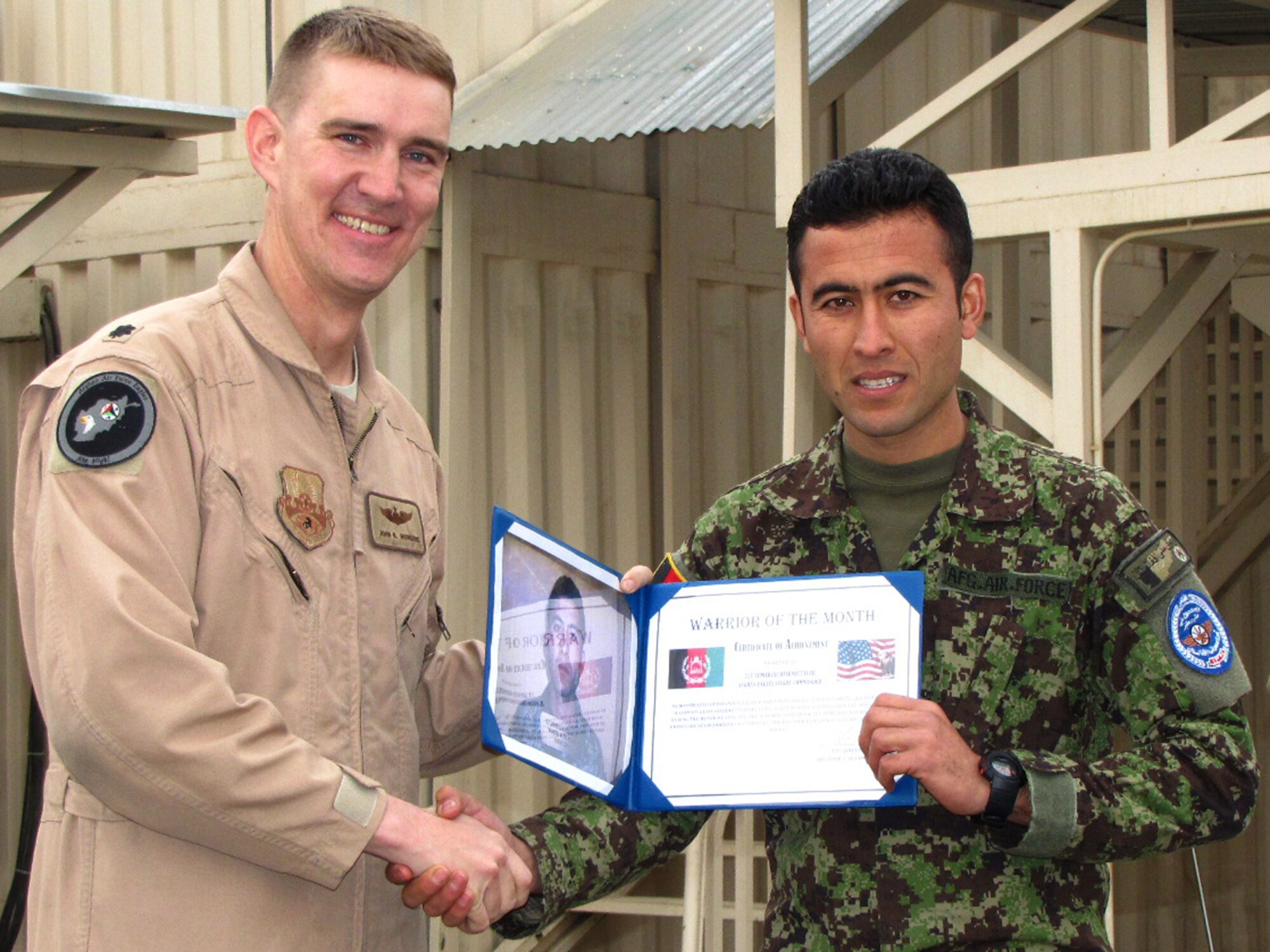 Afghan Air Force Lt. Hashmatullah, an “eagle” at the Thunder Lab, an English immersion program at the Afghan Air Force Base in Kabul receives the “Warrior of the Month” award from U.S. Air Force Lt. Col. John Howard, the officer-in-charge of the Thunder Lab, during a ceremony Feb. 3. (U.S. Navy photo by Mass Communications Specialist 2nd Class Vladimir Potapenko/RELEASED)