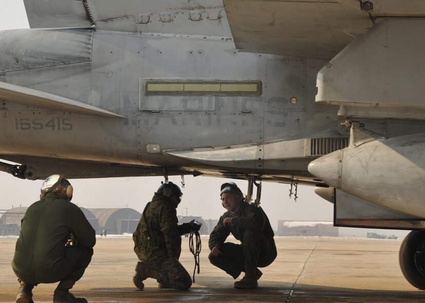 Marine maintainers from the Marine Fighter Attack Squadron 225 inspect an F-18 Hornet at Osan Air Base, Republic of Korea, Feb. 2. The Marine squadron is currently on their unit deployment program, where they go to Marine Corps Air Station Iwakuni for six months in which they travel around the Pacific region for a few weeks at a time to train their aircrew in different environments. (U.S. Air Force photo/Senior Airman Evelyn Chavez)