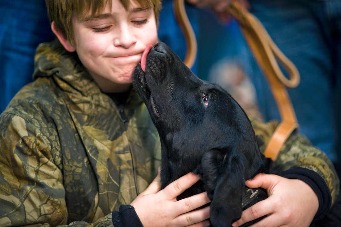 Brady Rusk, 12, hugs Eli, a former military working dog, at the ...