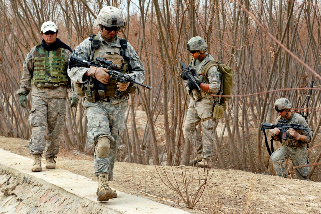 U.S. Army Sgt. Eduardo Avila leads his squad up an embankment during a foot patrol in the Arghandab district in Afghanistan's Kandahar province, Jan. 31, 2011.