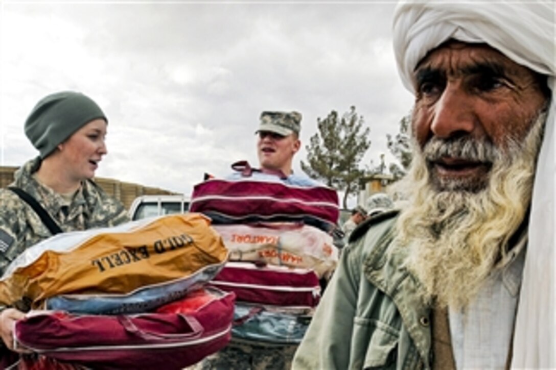 U.S. forces help distribute blankets, coats, wool caps and scarves to local village elders in Shindand in Afghanistan's Herat province on Feb. 2, 2011.  The NATO Air Training Command Afghanistan provided the materials, which members of the 838th Air Expeditionary Advisory Group distributed.  