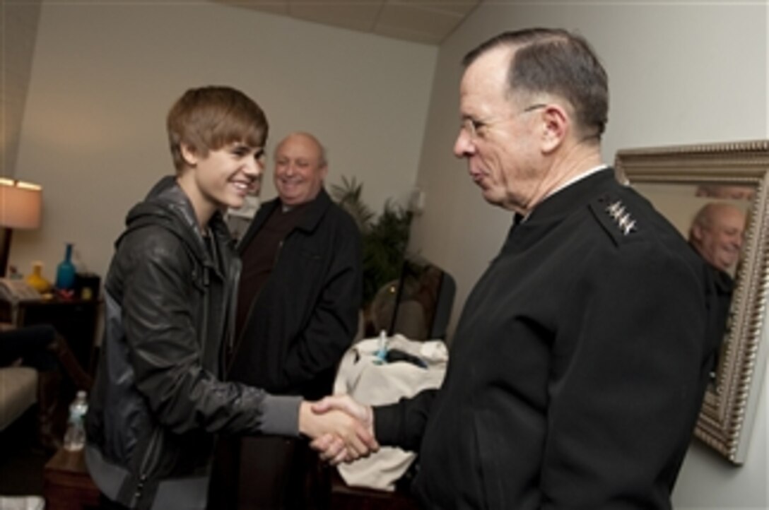 Chairman of the Joint Chiefs of Staff Adm. Mike Mullen, U.S. Navy, greets pop star Justin Bieber prior to an appearance on The Daily Show with Jon Stewart in New York City on Feb. 3, 2011.  