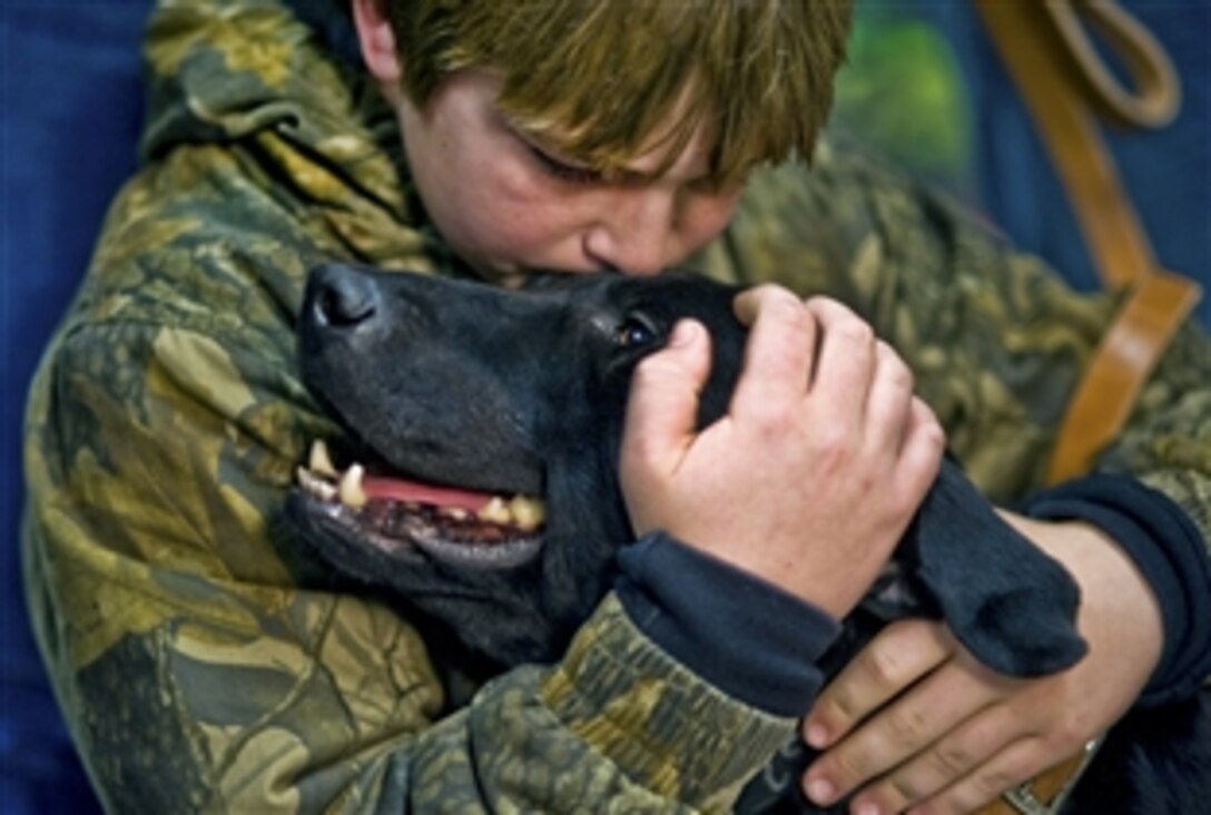 Brady Rusk, 12, hugs Eli, a former military working dog, at the Labrador retreiver's retirement and adoption ceremony on Lackland Air Force Base, Texas, Feb. 3, 2011. Eli was in Afghanistan assigned to Brady's brother, U.S. Marine Corps Pfc. Colton Rusk, who was killed Dec. 5, 2010. The former bomb-sniffing dog will live out his days with Rusk's family in Orange Grove, Texas.