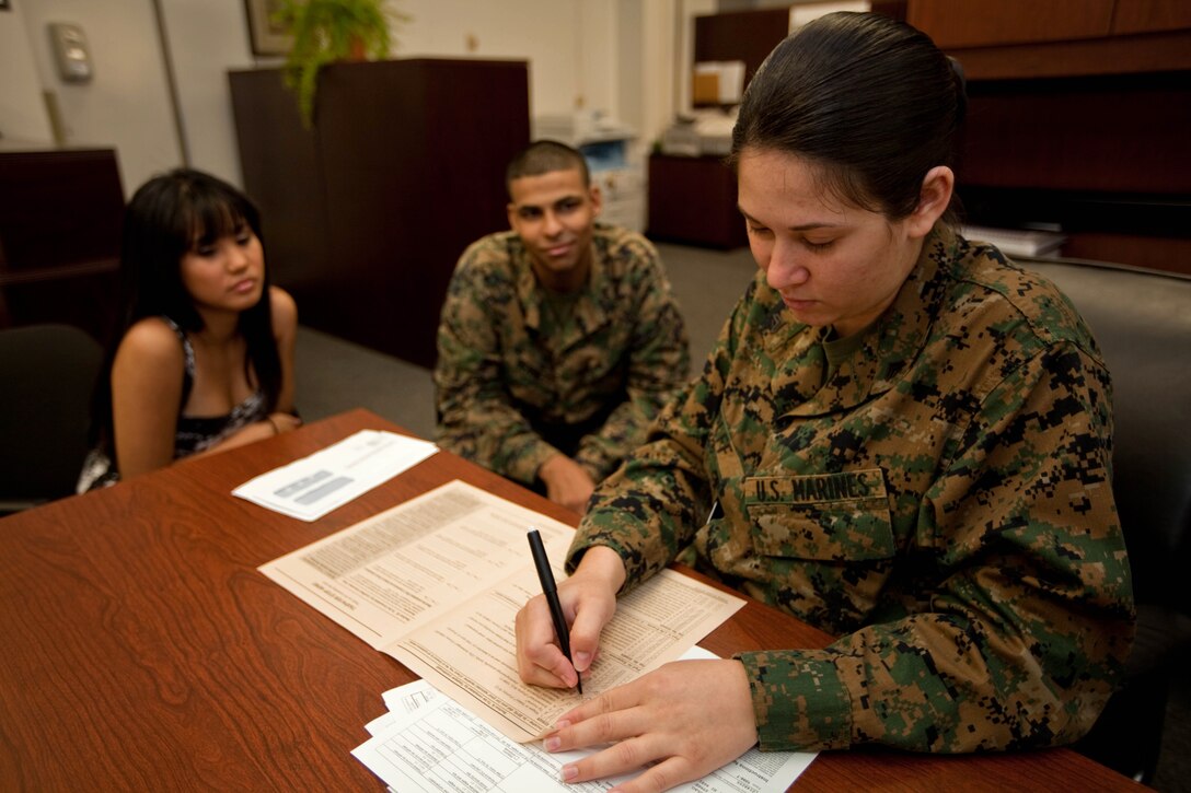 Cpl. Lianny Wolff, a legal clerk with the U.S. Marine Corps Forces, Pacific, Staff Judge Advocate Office, helps  Cpl. Patrick A. Bennett, a plans and operations clerk with MarForPac, with filing his taxes Feb. 4 here.::r::::n::MarForPac’s SJA Office offers free tax filing assistance to all service members, their spouses and retired personnel on the island.