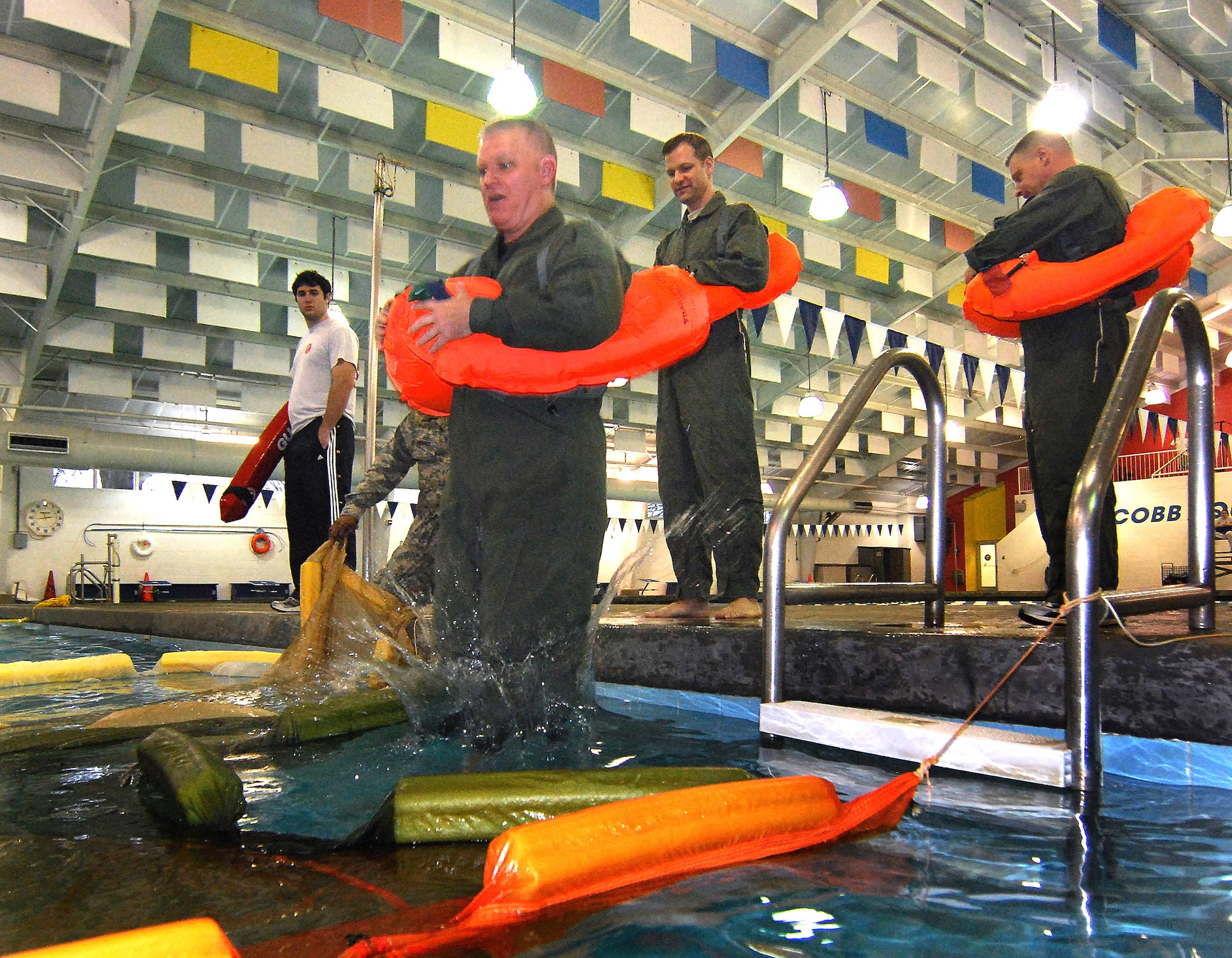 C-130 navigator, Lt. Col. Walter Koelln, takes the plunge with his aircrew life preserver into the semiannual water survival training for 94th Airlift Wing aircrew members, 4 Feb.  Aircrew personnel are required to receive this training once every three years to stay proficient with the equipment and techniques used in various water survival situations.  The Aircrew Flight Equipment Continuation instructors conduct this training twice a year and have partnered with Cobb County to use the Cobb Aquatic Center in Marietta, Ga., for each winter session to ensure a safe training environment.  (U.S. Air Force photo/ Brad Fallin)
