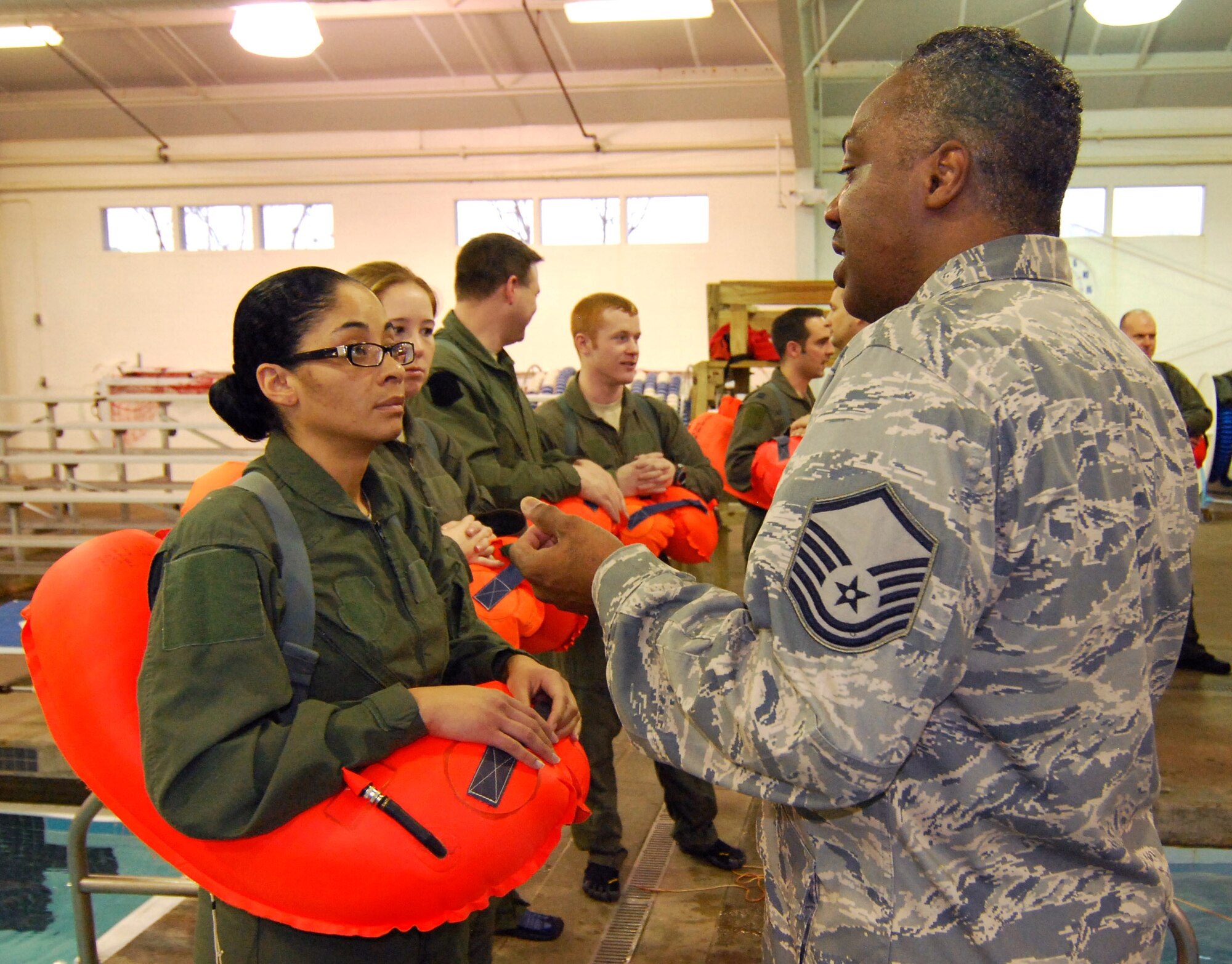 Tech Sgt. Susan Robinson, an Aerospace Medical Technician, talks with Master Sgt. Mike Varnado, Aircrew Flight Equipment Training NCOIC, about the water survival training she is about to jump into, 4 Feb.  Aircrew personnel are required to receive this training once every three years to stay proficient with the equipment and techniques used in a water survival situation.  The Aircrew Flight Equipment Continuation instructors conduct this training twice a year and have partnered with Cobb County to use the Cobb Aquatic Center in Marietta, Ga., for each winter session to ensure a safe training environment.  (U.S. Air Force photo/ Brad Fallin)