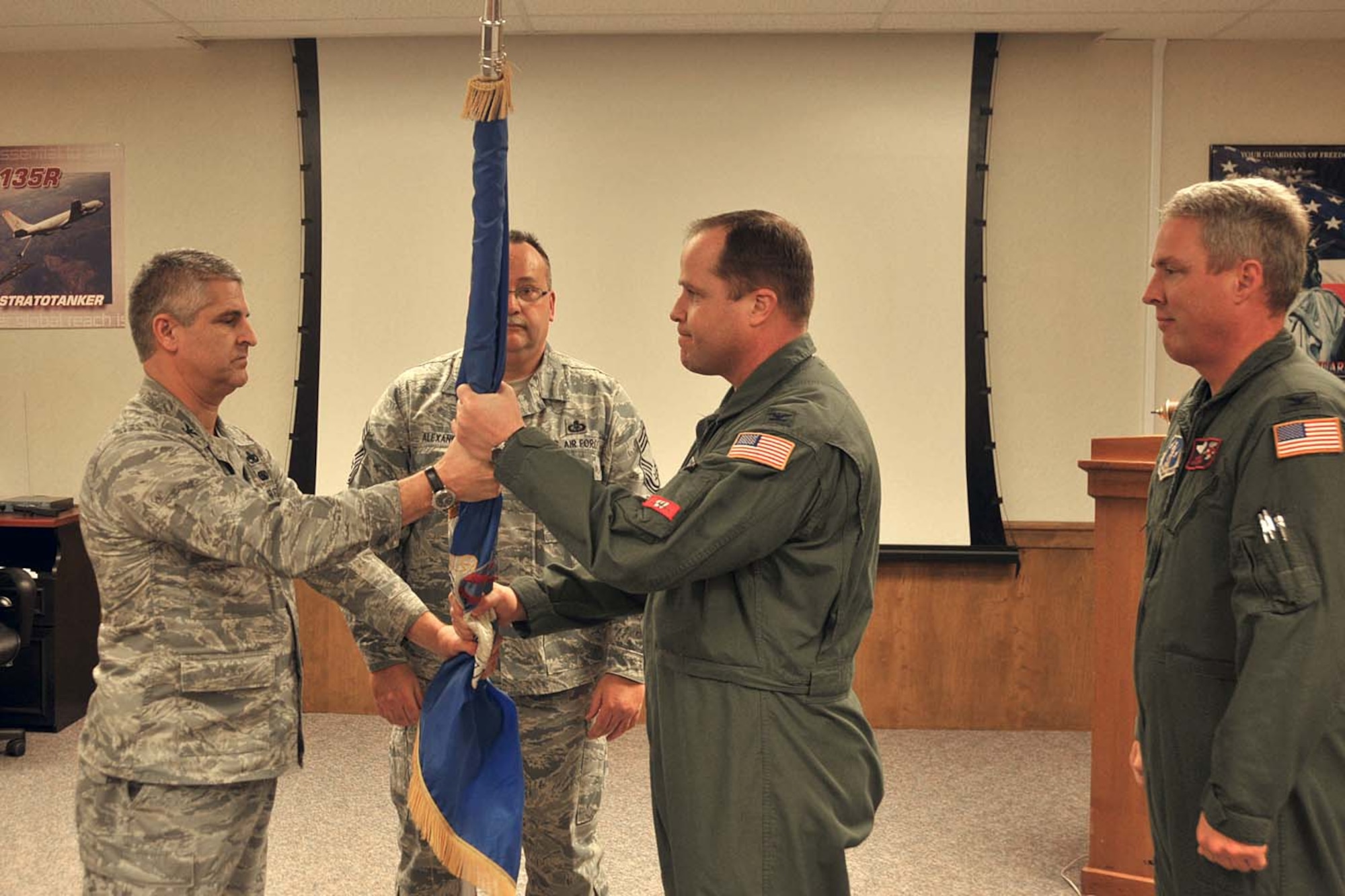 Col. John Puttre (left) , 128th Vice-Commander, accepts the guideon from outgoing maintenace commander Col. John Locke Saturday, 5 February, 2011. Col. Locke's new assignment will as  commander of the 128th Operations Group, taking over that position from Col. Michael Mayo (right). Col. Mayo is to be come the new Vice Commander for the 128th.