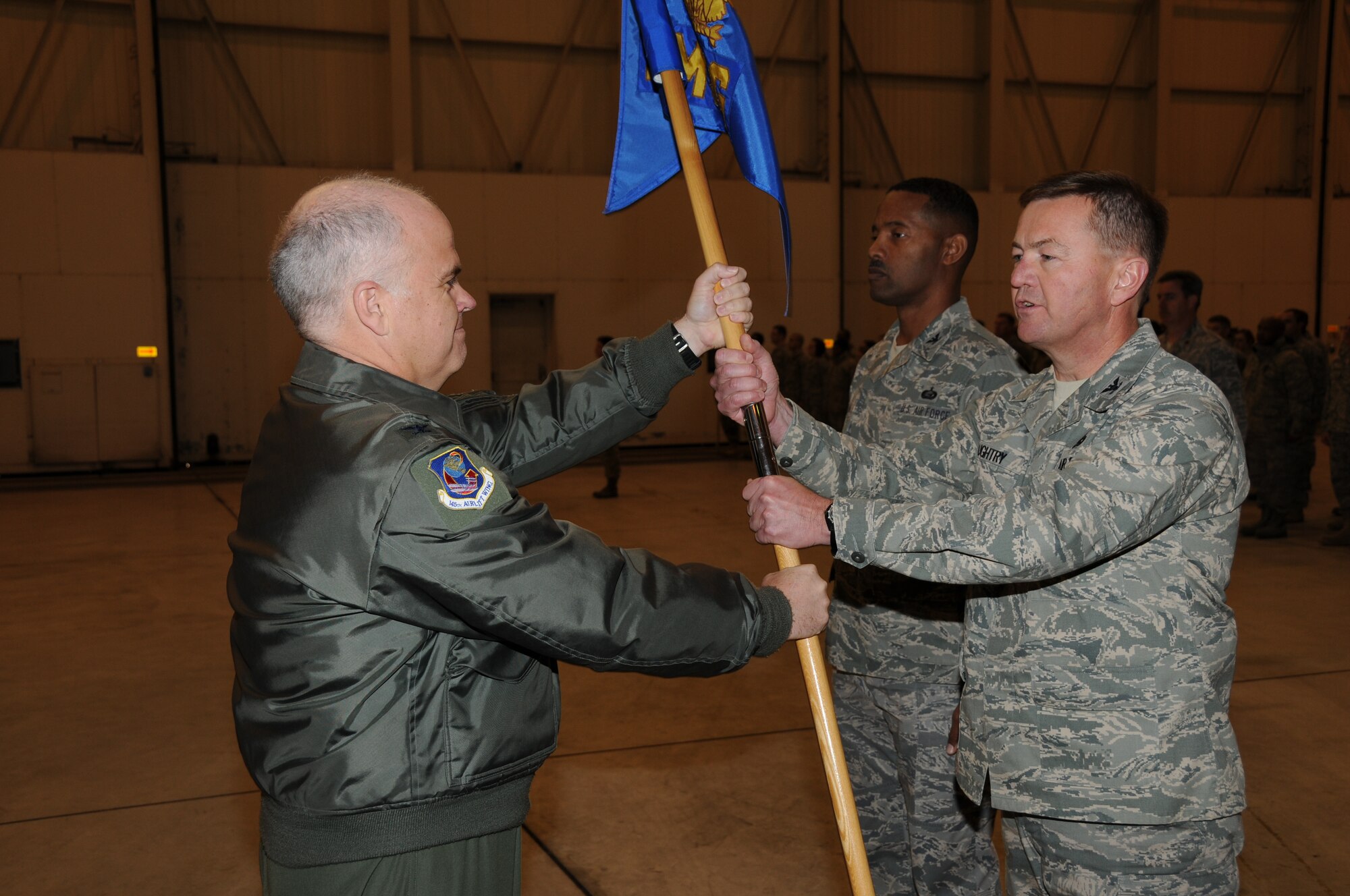 Charlotte, N.C. Col Tony McMillan presents Col Hugh Daughtry the 145th Mission Support Group guidon during the change of command ceremony on December 5, 2010. Photo by Tech. Sgt. Richard Kerner.