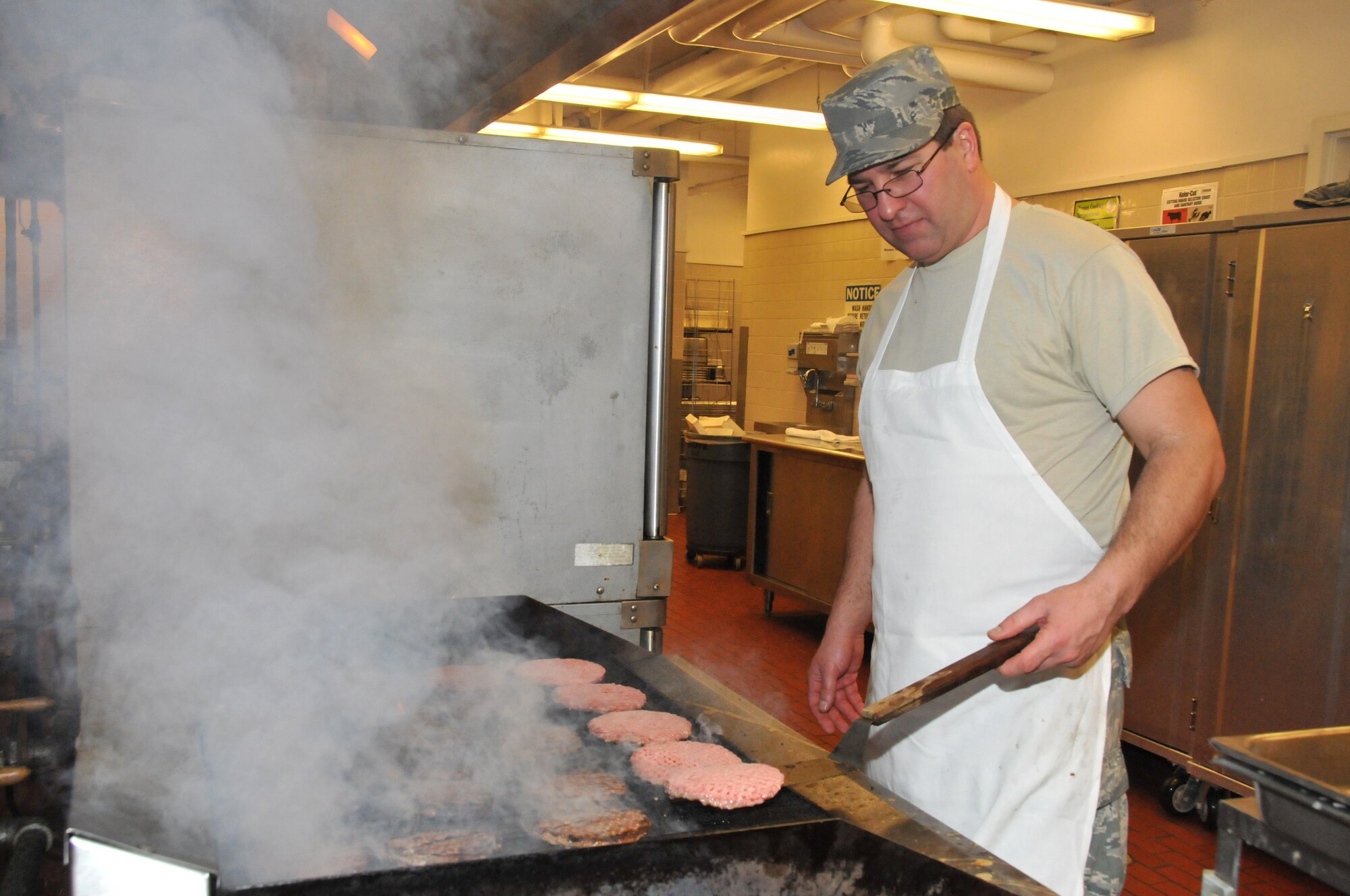 Staff Sergeant Ted Stankiewicz of the 934th Services Squadron flips hamburgers at the Dining Facility, Minneapolis Air Reserve Station, Minnesota, on February 6, 2011.  The 934th Services Squadron Dining Facility was inspected over the weekend by the Hennessy Travelers Association and subsequently awarded a coin for outstanding teamwork, dedication and service. (U.S. Air Force photo/Staff Sergeant  Noah R. Johnson)