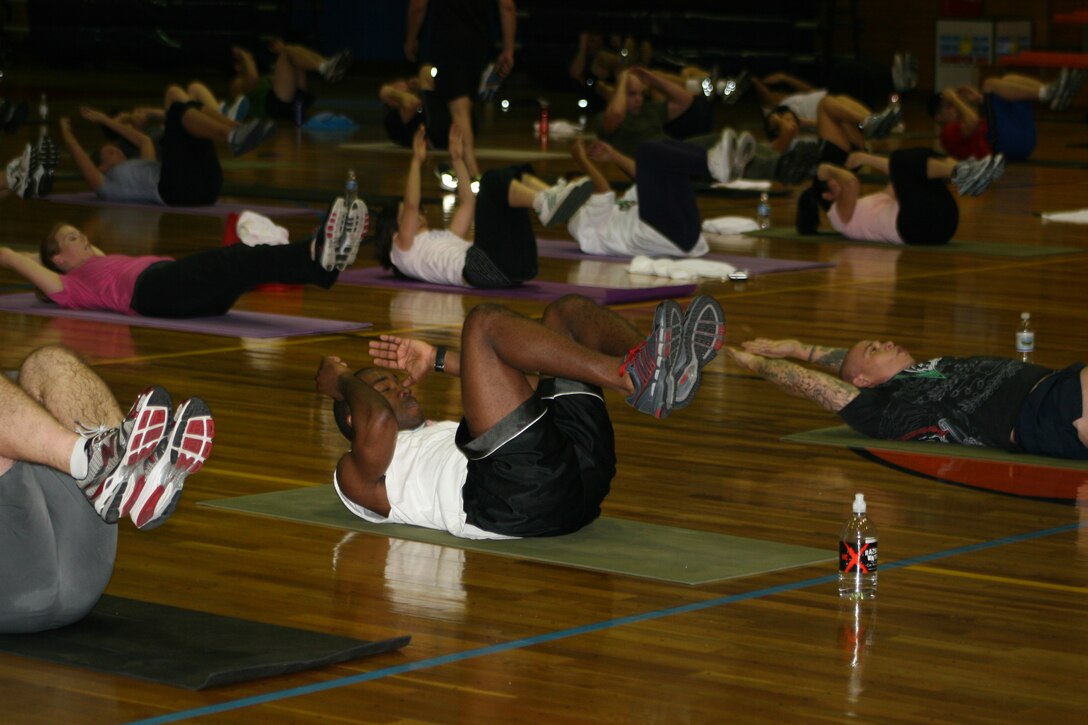 A group of residents work their abdominal muscles during a P90X workout as fitness guru and P90X creator Tony Horton walks through encouraging them here Monday. Horton was also on hand afterward for an additional evening book signing and meet-and-greet with residents.