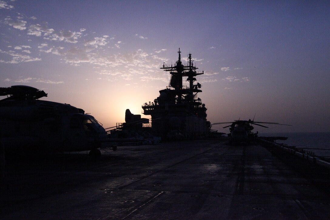 (Feb. 7, 2011) – Dawn breaks over the USS Kearsarge before the Run To Nowhere, a 5K race held Feb. 7, 2011. Marines and sailors with 26th Marine Expeditionary Unit and USS Kearsarge participated in the run, which spanned from the bow to the stern of the ship as well as the cavernous hangar bay. Elements of 26th MEU are currently operating aboard ships of the Kearsarge Amphibious Ready Group in the U.S. 5th Fleet area of responsibility. (Official USMC photo by Lance Cpl. Michael S. Lockett)::r::::n::