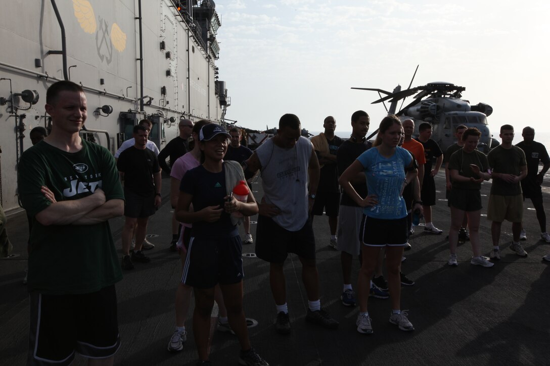 USS KEARSARGE, At Sea (Feb. 7, 2011) – Participants relax during the Run To Nowhere awards ceremony held Feb. 7, 2011. Winners of each age group and a random lottery were awarded a variety of prizes. Marines and sailors with 26th Marine Expeditionary Unit and USS Kearsarge participated in the 5K race, which spanned from the bow to the stern of the ship as well as the cavernous hangar bay. Elements of 26th MEU are currently operating aboard ships of the Kearsarge Amphibious Ready Group in the U.S. 5th Fleet area of responsibility. (Official USMC photo by Lance Cpl. Michael S. Lockett)::r::::n::