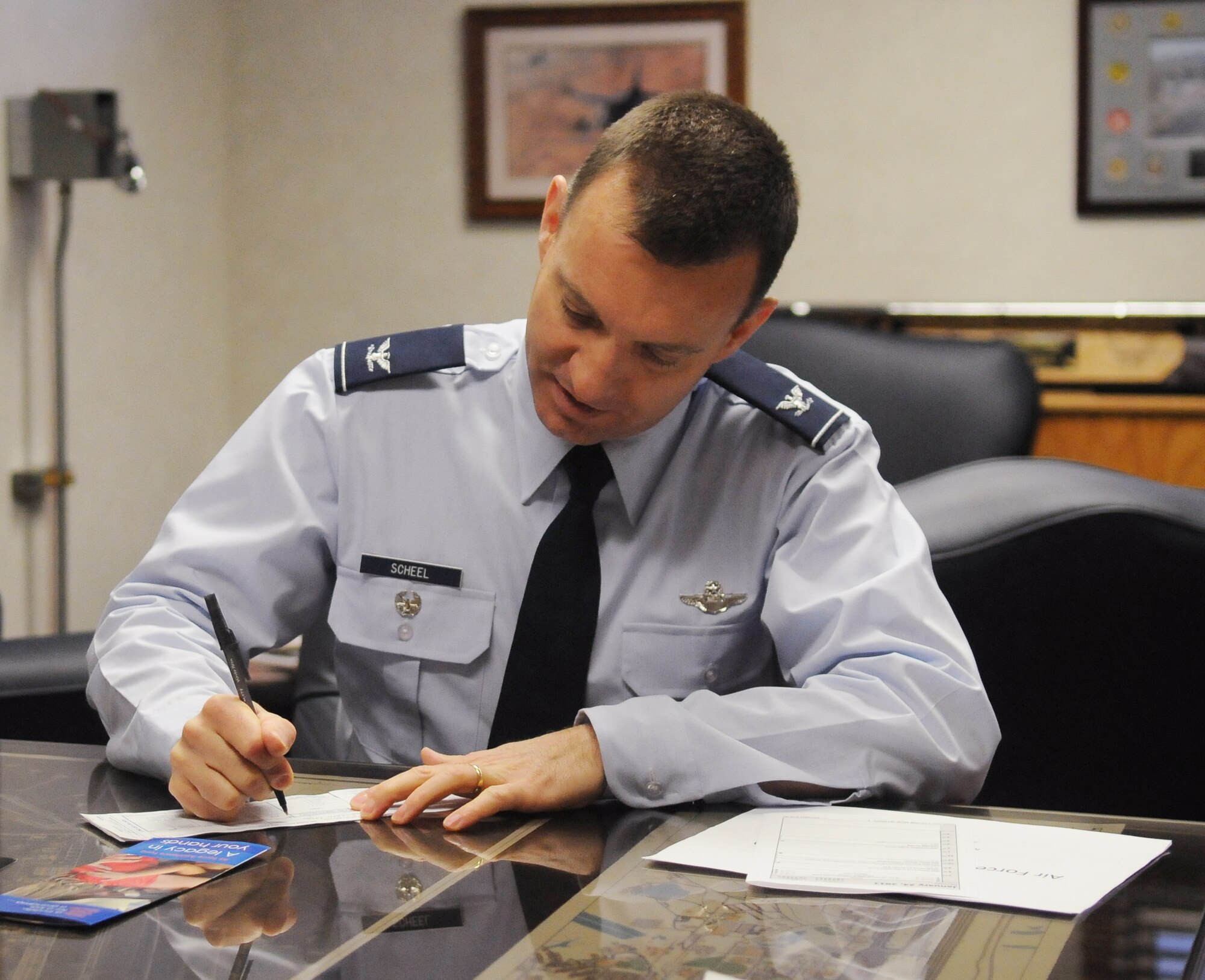 Colonel Lynn Scheel signs his donation for the Air Force Assistance Fund Jan. 24, 2011, Eielson Air Force Base, Alaska. Last year, the AFAF raised $7.49M Air Force wide. Col. Scheel is the Vice Commander of the 354th Fighter Wing.