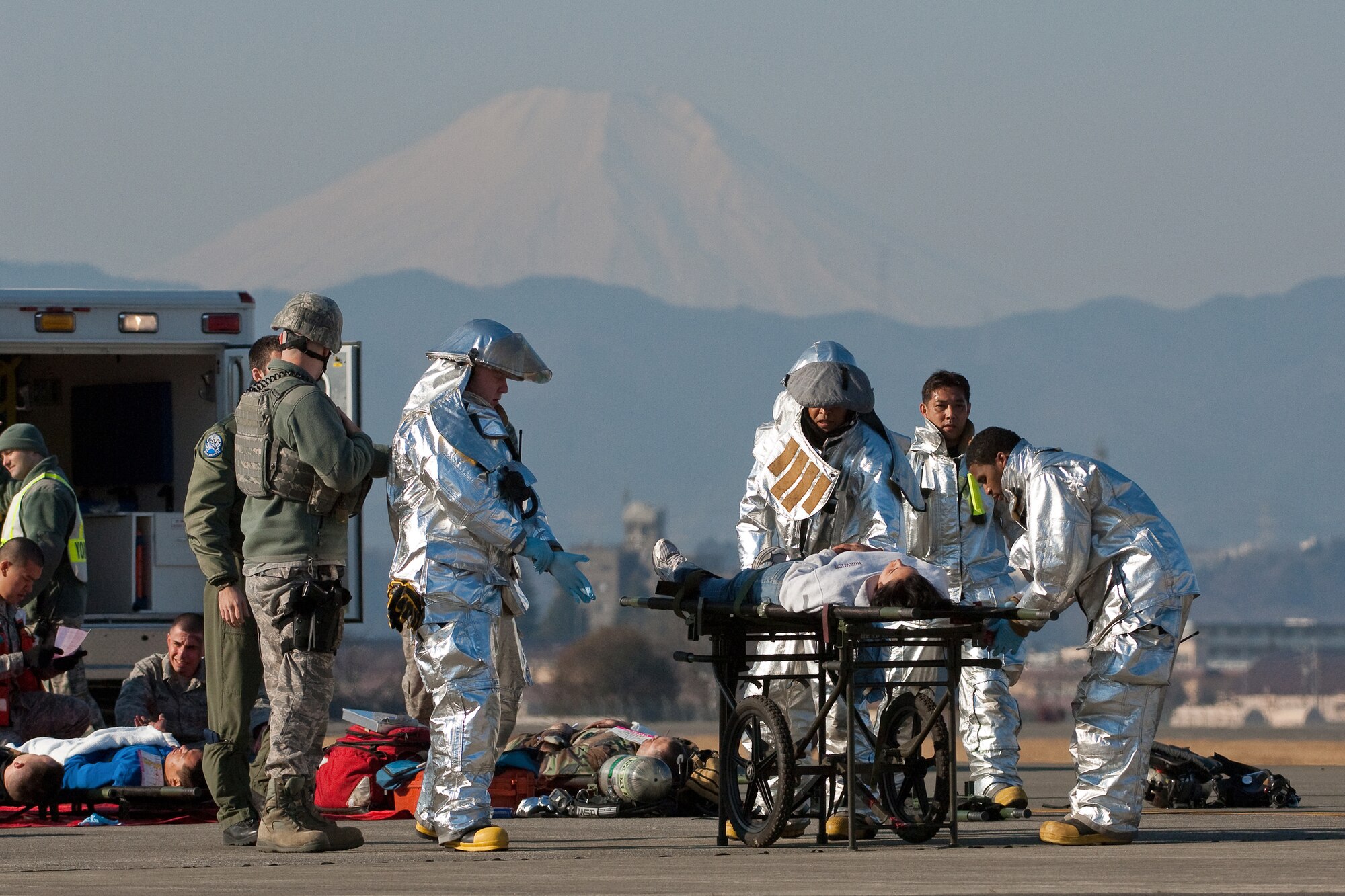YOKOTA AIR BASE, Japan -- Firefighters from the 374th Civil Engineer Squadron transport a patient to the casualty collection point following a simulated aircraft crash during an Emergency Management Exercise here Feb. 4. (U.S. Air Force photo/Osakabe Yasuo) 