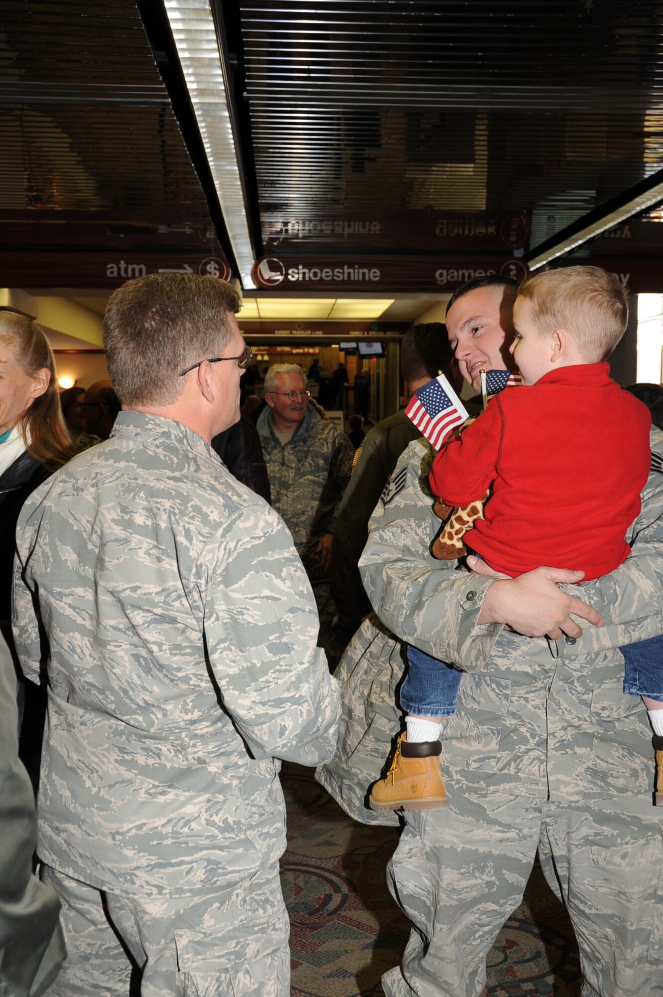 Staff Sgt. Edward Allred of the 931st Civil Engineering Squadron is greeted by his son, Aiden, 5, and Lt. Col. Jeffrey Pickard, Deputy Commander for Maintenance, 931st Air Refueling Group, upon his return from a deployment in Southwest Asia, Feb. 4. Members of the 931st ARG showed up at the Midcontintinental Airport in Wichita to support Sergeant Allred and five other reservists from the 931st CES. (Air Force Photo by Tech. Sgt. Brannen Parrish)