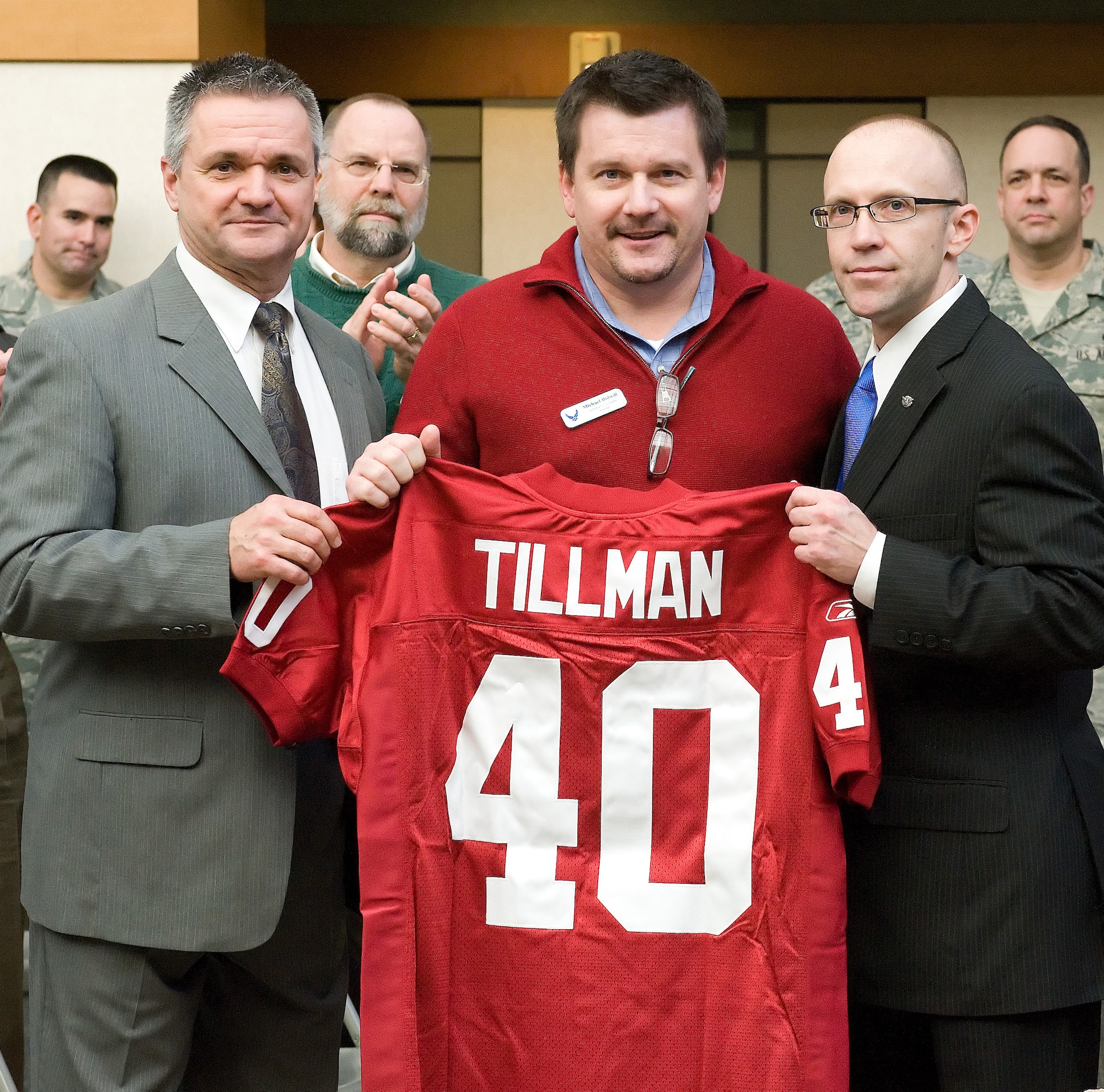 William Zwicharowski (left), Michael Bidwill, president of the Arizona Cardinals Football Club, and Trevor Dean, deputy to the commander, Air Force Mortuary Affairs Operations pose with the Pat Tillman jersey Mr. Bidwill presented to AFMAO during a civic leader tour. (U.S. Air Force photo/Jason Minto)
