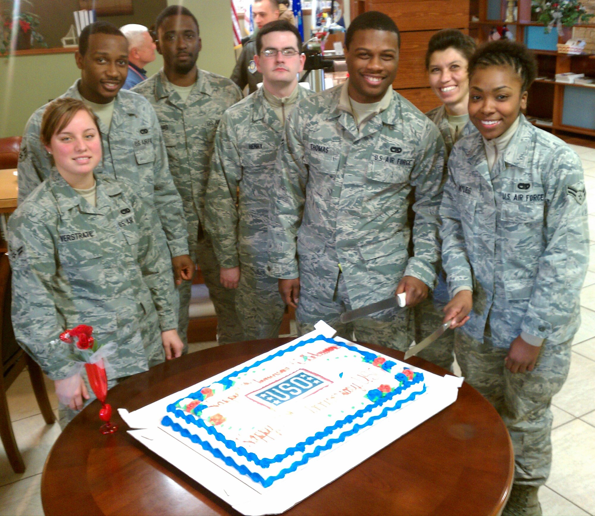 Airmen from the 436th Aerial Port Squadron prepare to cut the cake at a celebration for the Delaware USO?s 20th anniversary celebration, and the USO?s 70th anniversary at Dover AFB, Del., Feb. 04, 2011. For 70 years, the USO has been providing America's troops and their families programs and services. (Photo by Joan Cote)