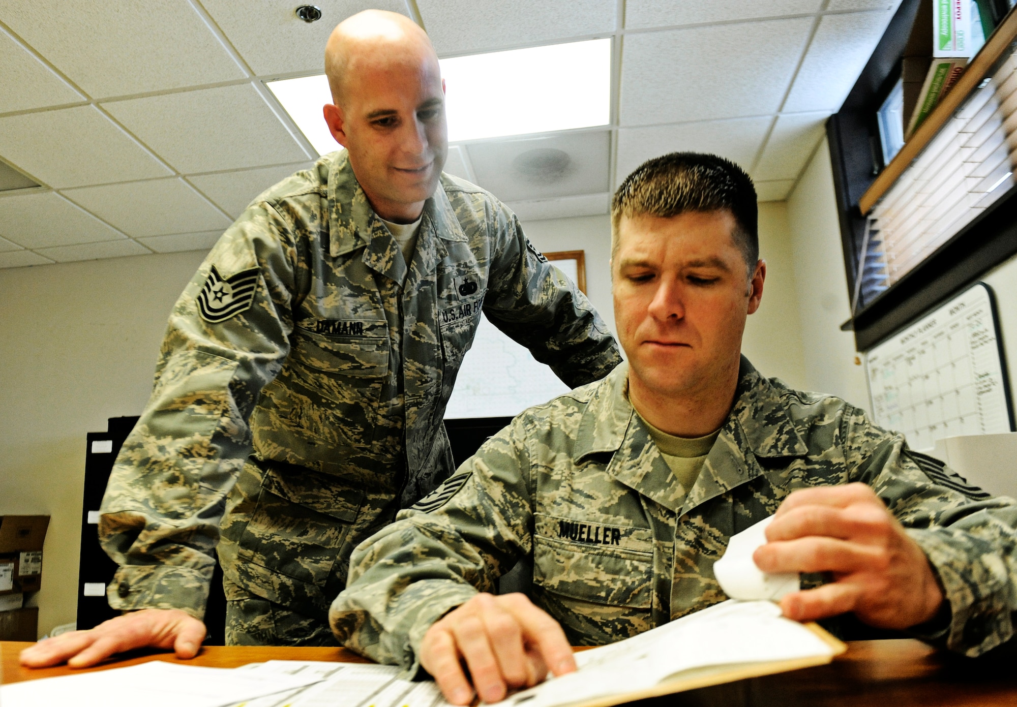 Tech Sgts. Ed Mueller and Gustav Damann, 375th Logistics Readiness Squadron control center operators, review fuel log records Feb 4, 2011 at Scott Air Force Base. The petroleum, oils and lubricants flight control center is responsible for dispatching fuels operators to aircraft, and maintaining logs of fuel usage. (U.S. Air Force photo/ Staff Sgt. Ryan Crane)