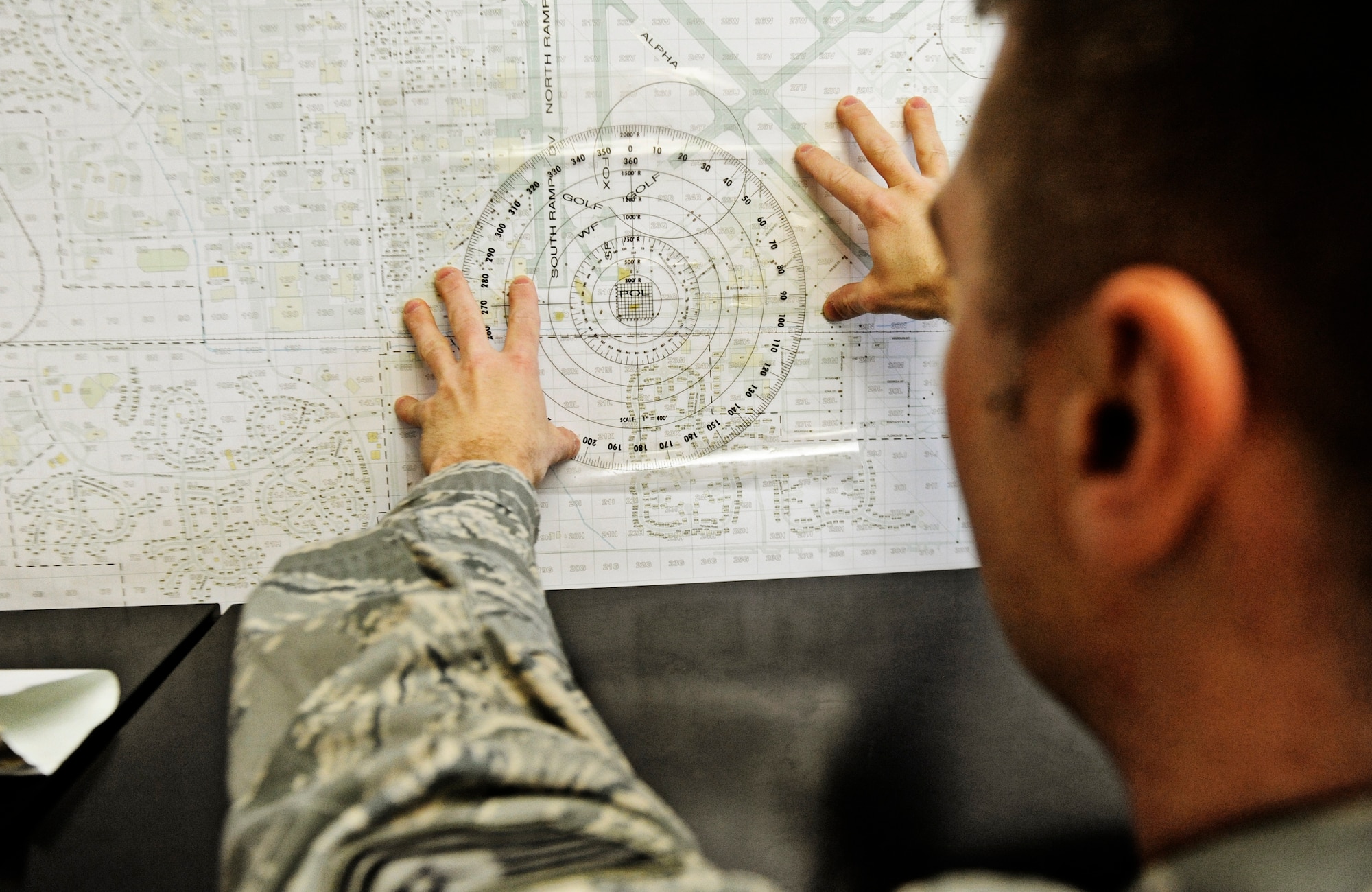 Tech Sgt. Ed Mueller, 375th Logistics Readiness Squadron control center NCO in charge, uses a grid map of the base to locate the fuels station in relation to the flight line Feb 4, 2011 at Scott Air Force Base. The petroleum, oils and lubricants flight control center is responsible for dispatching fuels operators to aircraft, and maintaining logs of fuel usage. (U.S. Air Force photo/ Staff Sgt. Ryan Crane)