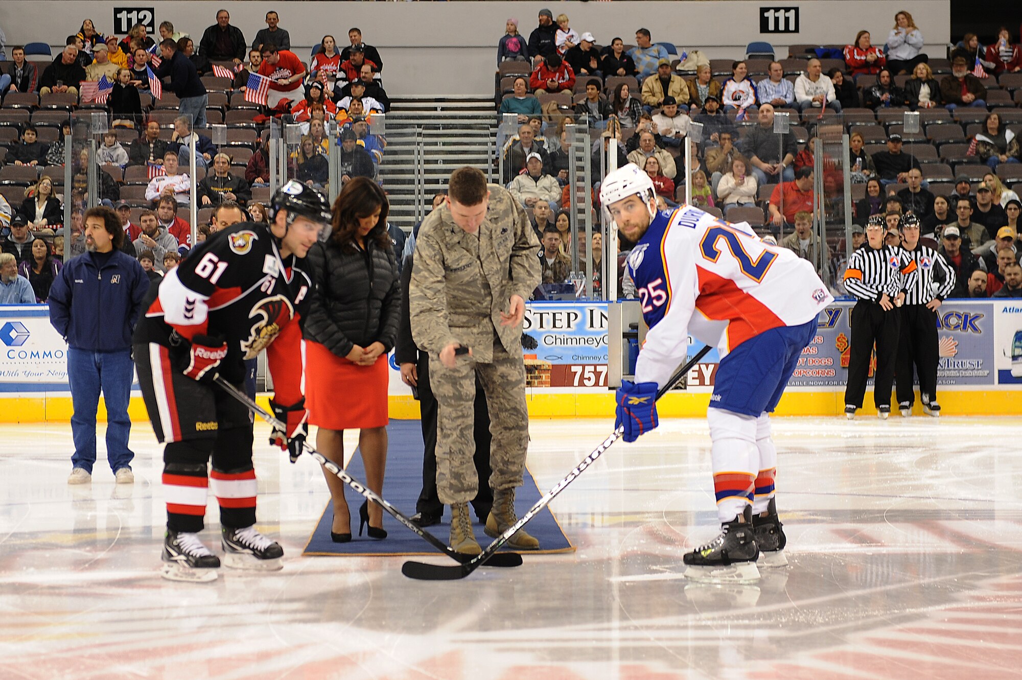 NORFOLK, Va. – Team captains Andre Benoit, Binghamton Senators, and Chris Durno, Norfolk Admirals, meet center rink as Col. Donald Kirkland, 633d Air Base Wing commander, tosses the puck for the start of the military appreciation game at the Norfolk Scope Arena Feb. 4.  The Admirals topped the Binghamton Senators, 4-3, with a game-winner power play goal in overtime.  (U.S. Air Force Photo/Senior Airman Antoinette Gibson) (RELEASED)
