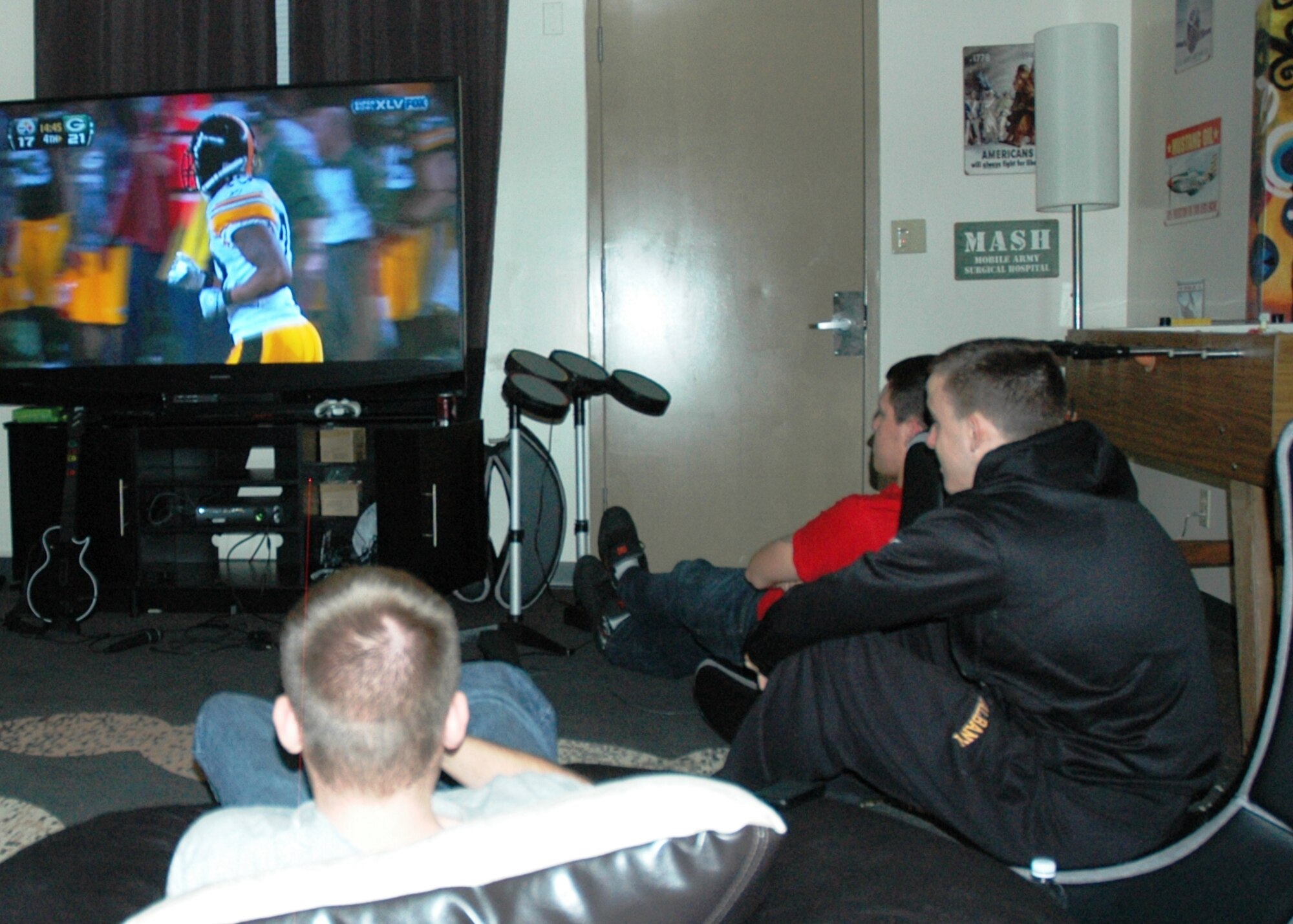 Airmen watch the NFL Super Bowl at Eglin's new Airmen Center called "Lighthouse" located at Dorm 18 D's third floor. The football match drew 37 dorm residents to the new seven-room complex Feb. 6. A full kitchen, video gaming options, music studio and surround sound TV viewing options with screens up to 73” make up the decked out center. Entrance for the facility is accessible from the Airmen Leadership School's parking lot. (U.S. Air Force photo/Chrissy Cuttita)