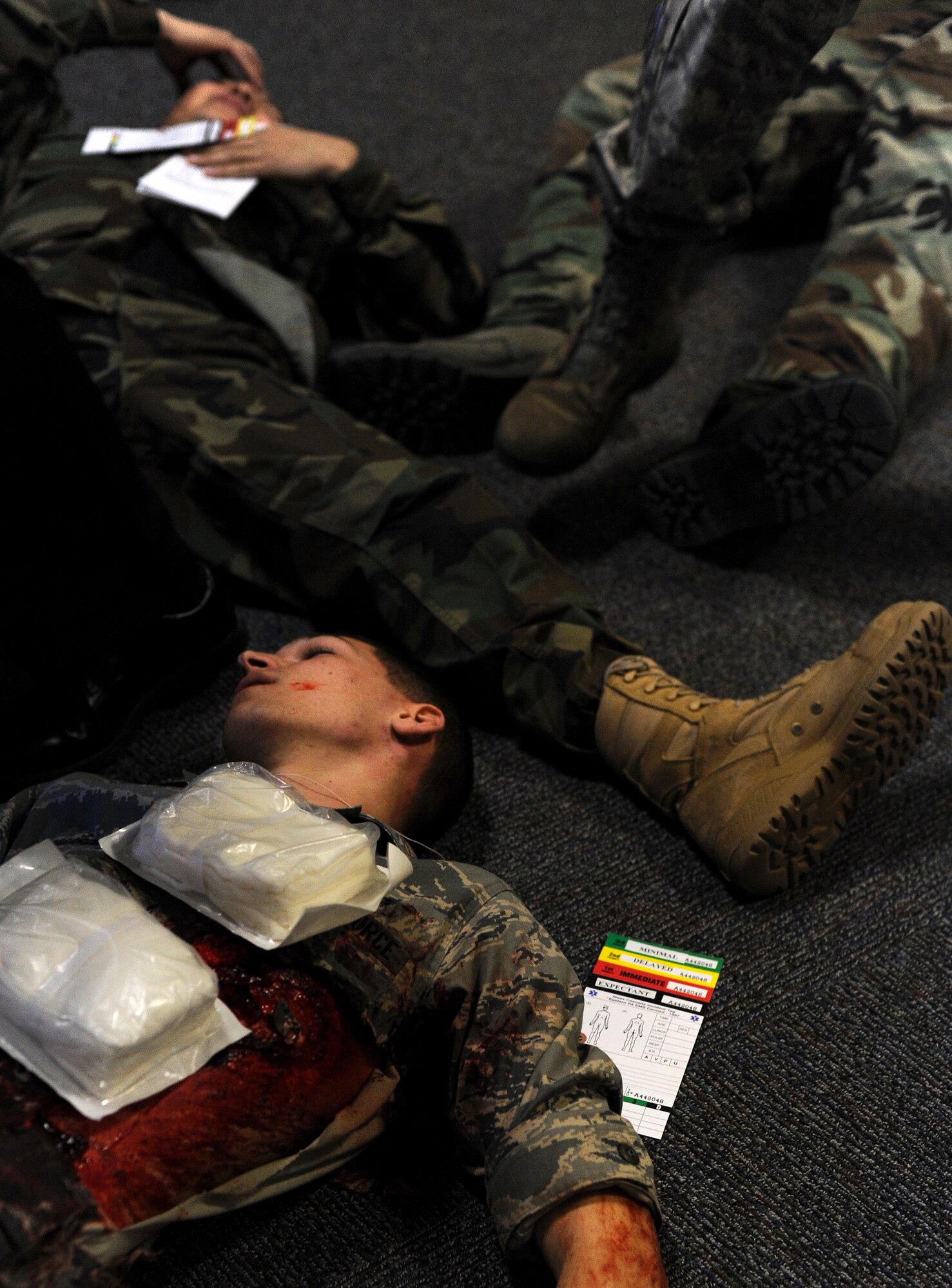 Bodies of casualties lay head to foot as the 509th Medical Group Airmen scramble to render aid to as many wounded as possible during a mass casualty exercise, Feb. 4, 2011, Whiteman Air Force Base. Airmen spent several hours responding to an explosion scenario where more than 50 Airmen and civilians had been severely injured and were in need of immediate medical aid. Whiteman medics performed the exact procedures they would in a real world situation to include loading patients into ambulances for transport to medical facilities.  (U.S. Air Force photo by Senior Airman Kenny Holston)(Released) 
