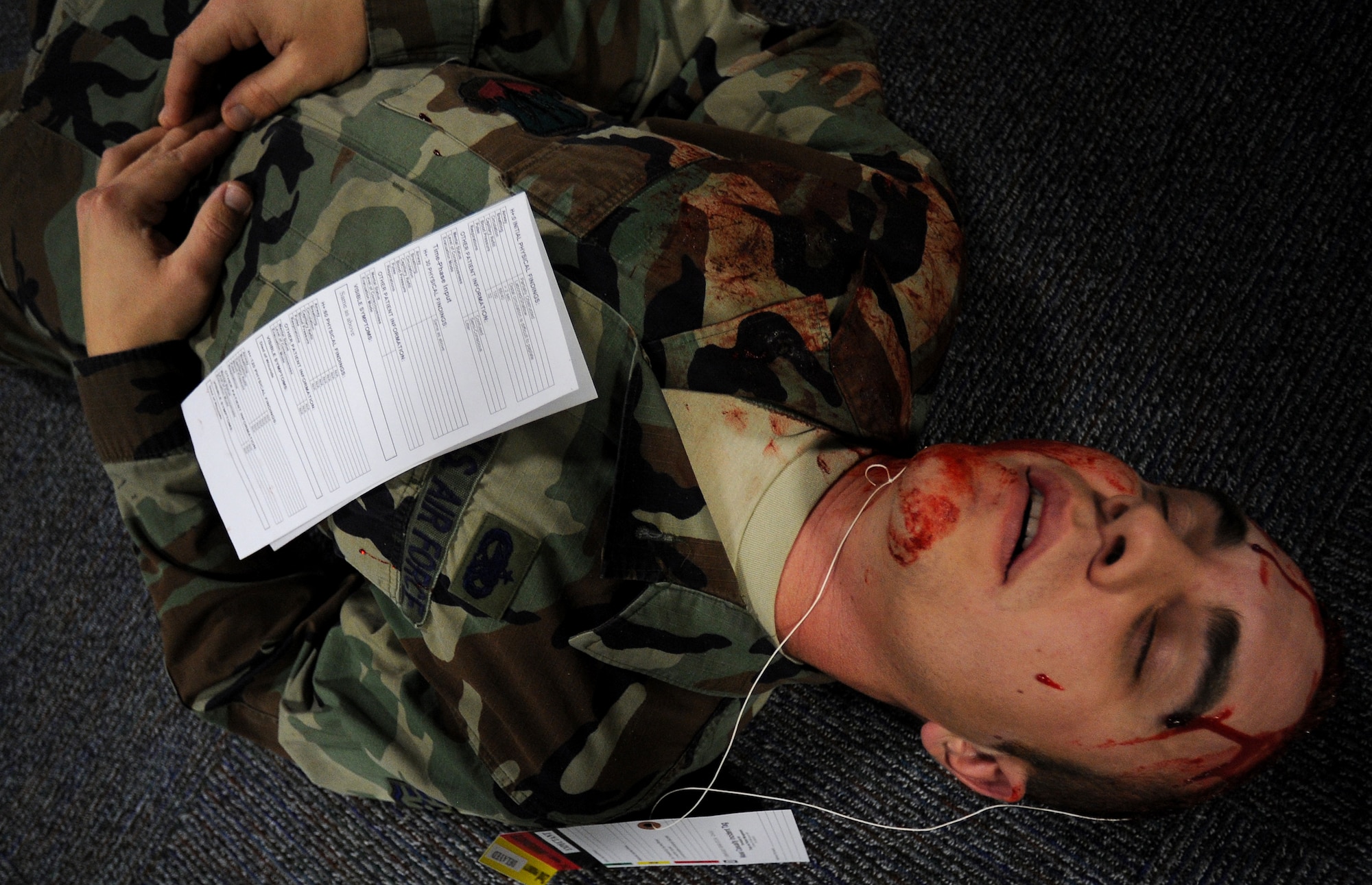 An Airman simulates death from sever wounds suffered from an explosion during a mass casualty exercise, Feb. 4, 2011, Whiteman Air Force Base. Airmen spent several hours responding to an explosion scenario where more than 50 Airmen and civilians had been severely injured and were in need of immediate medical aid. Whiteman medics performed the exact procedures they would in a real world situation to include loading patients into ambulances for transport to medical facilities.  (U.S. Air Force photo by Senior Airman Kenny Holston)(Released) 