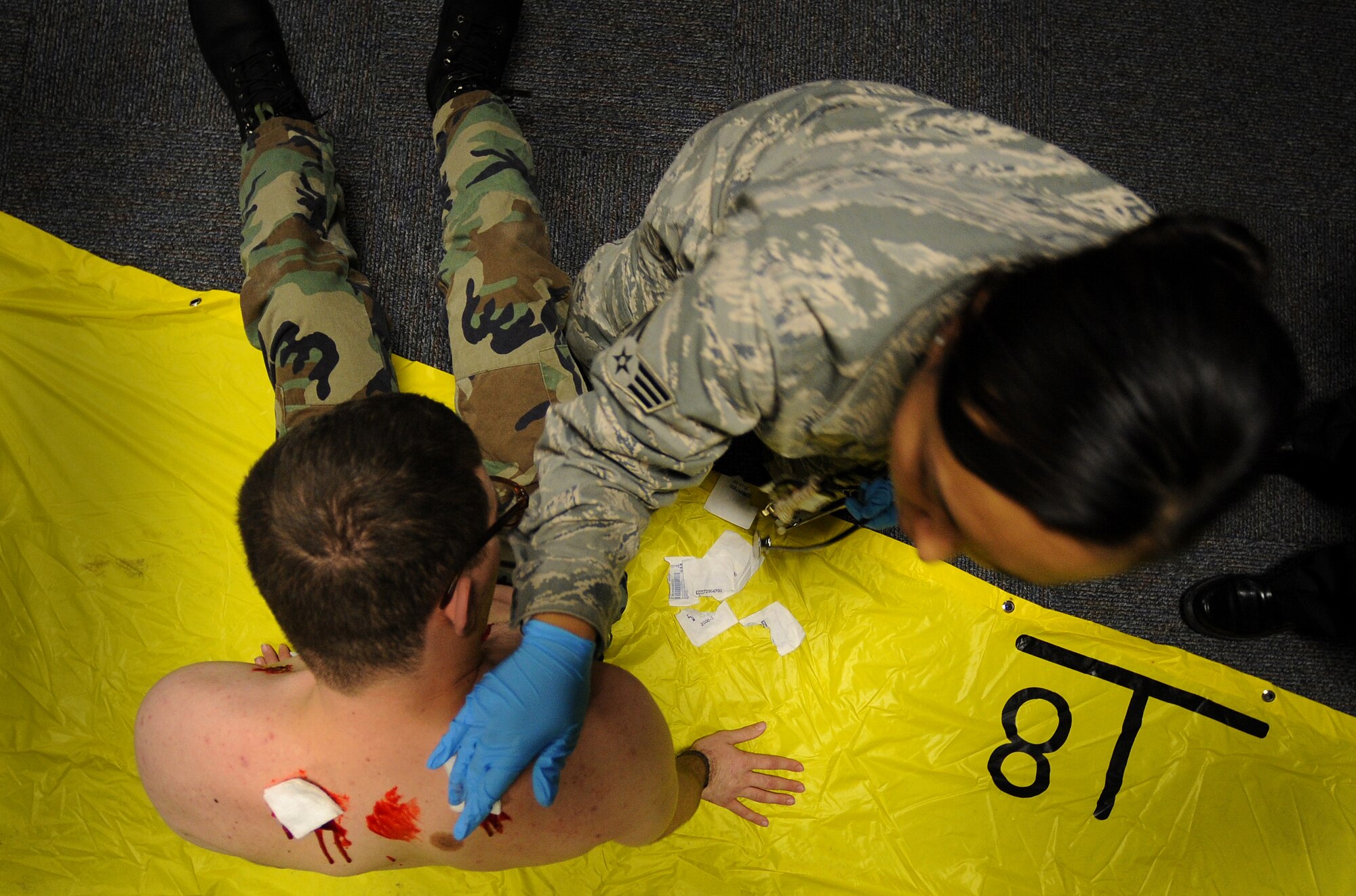 A 509th Medical Group senior airman tends to a patient's wounds during a mass casualty exercise, Feb. 4, 2011, Whiteman Air Force Base. Airmen spent several hours responding to an explosion scenario where more than 50 Airmen and civilians had been severely injured and in need of immediate medical aid. Whiteman medics performed the exact procedures they would in a real world situation to include loading patients into ambulances for transport to medical facilities.  (U.S. Air Force photo by Senior Airman Kenny Holston)(Released) 
