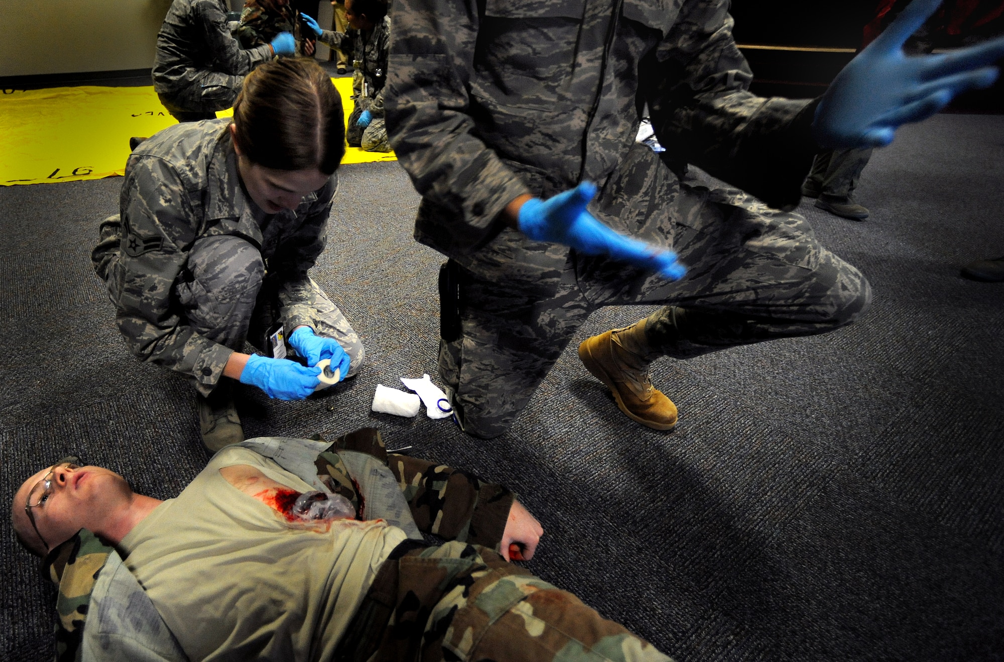 509th Medical Group Airmen scramble to render aid to a patient during a mass casualty exercise, Feb. 4, 2011, Whiteman Air Force Base. Airmen spent several hours responding to an explosion scenario where more than 50 Airmen and civilians had been severely injured and were in need of immediate medical aid. Whiteman medics performed the exact procedures they would in a real world situation to include loading patients into ambulances for transport to medical facilities.  (U.S. Air Force photo by Senior Airman Kenny Holston)(Released) 