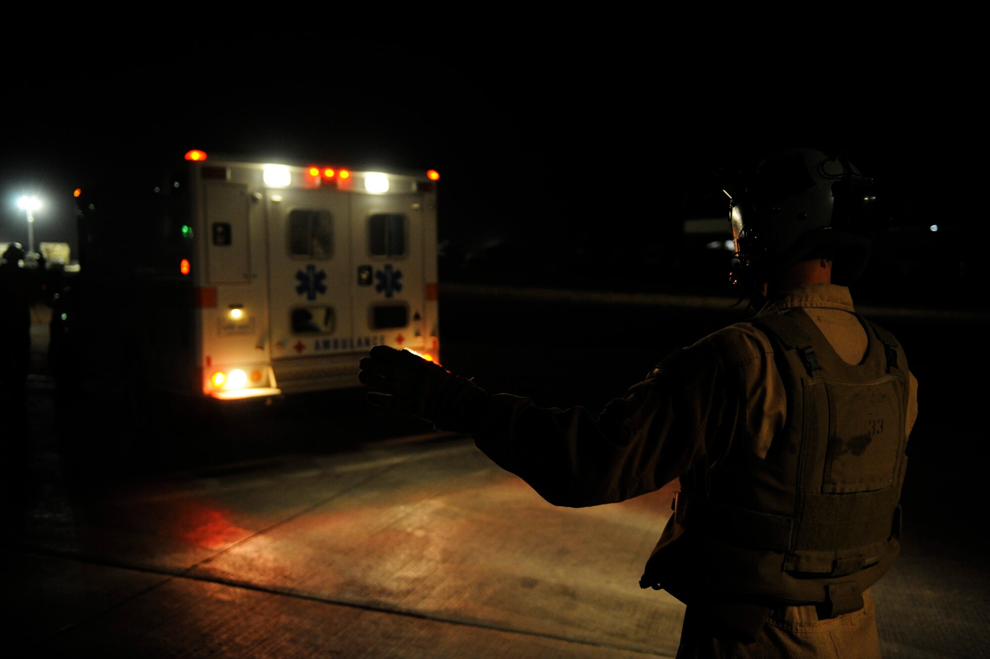 U.S. Air Force Master Sgt. Brad Simms guides an ambulance as it backs up near a C-130H Hercules to load patients aboard the aircraft at Camp Bastion, Afghanistan, Jan. 7, 2011.  C-130s are able to land on runways that many other fixed wing aircraft are unable to, making them invaluable when moving patients in austere locations. (U.S. Air Force photo by Staff Sgt. Eric Harris) 