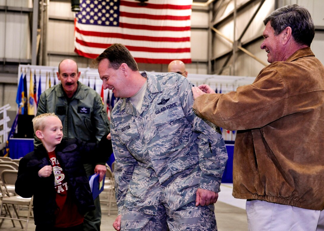 919th Special Operations Wing’s newest chief, Chief Master Sgt. Tyler Outten, 5th Special Operations Squadron, gets his stripes tacked on by his son and father during his induction ceremony at Duke Field, Fla.  (U.S. Air Force photo/Tech Sgt. Samuel King Jr.)