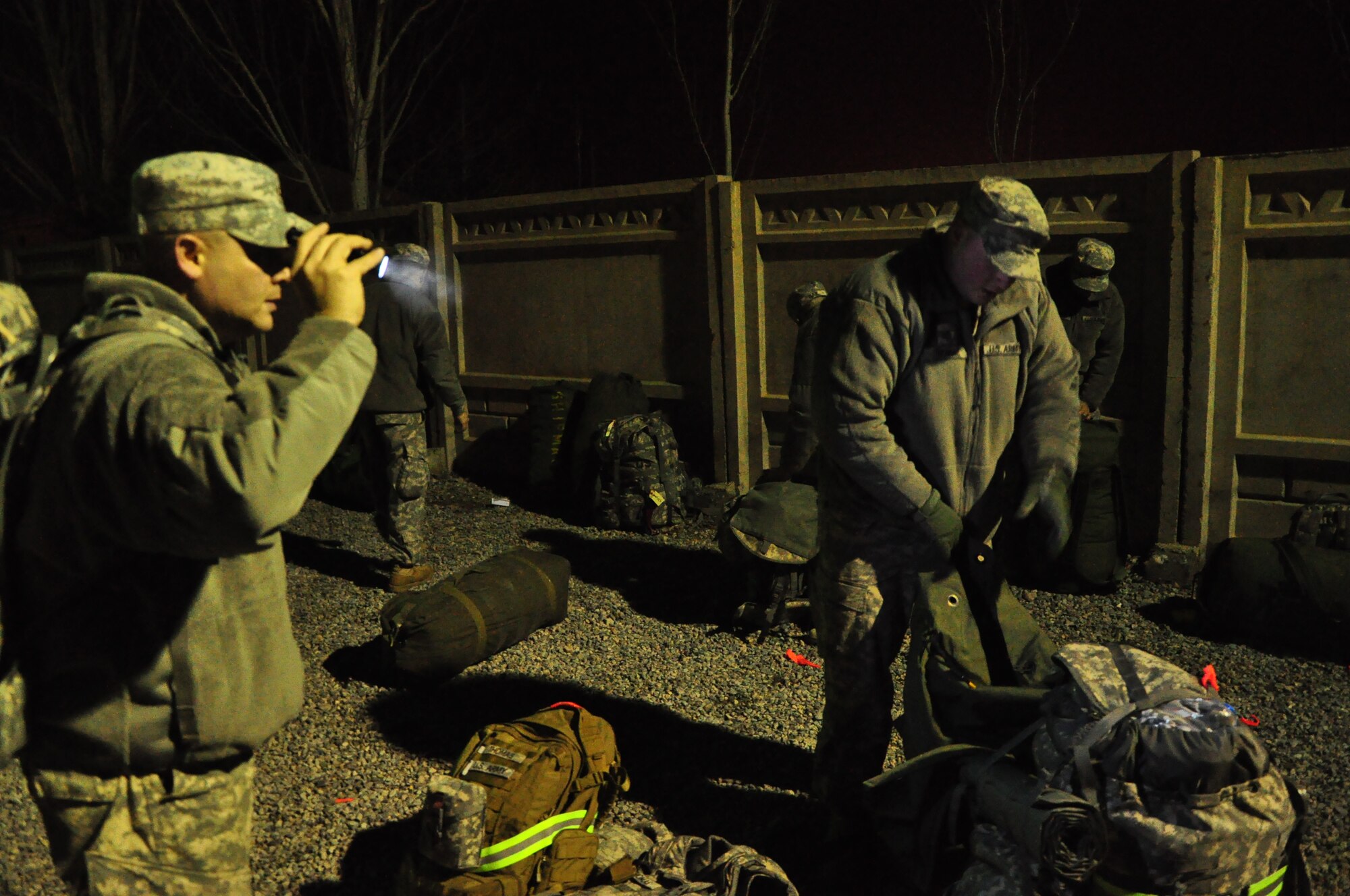 Army personnel gather their gear at night at the Transit Center at Manas. Scenes like this are a regular occurrence for the 24-hour, seven-day-a-week, operation at the Center supporting movement of personnel into and out of Afghanistan in support of Operation Enduring Freedom. Onward Movement of personnel is one of four mission pillars of the Center. The other three are Airlift, Air Refueling and Humanitarian Assistance. (U.S. Air Force photo/Master Sgt. Daniel Nathaniel III)