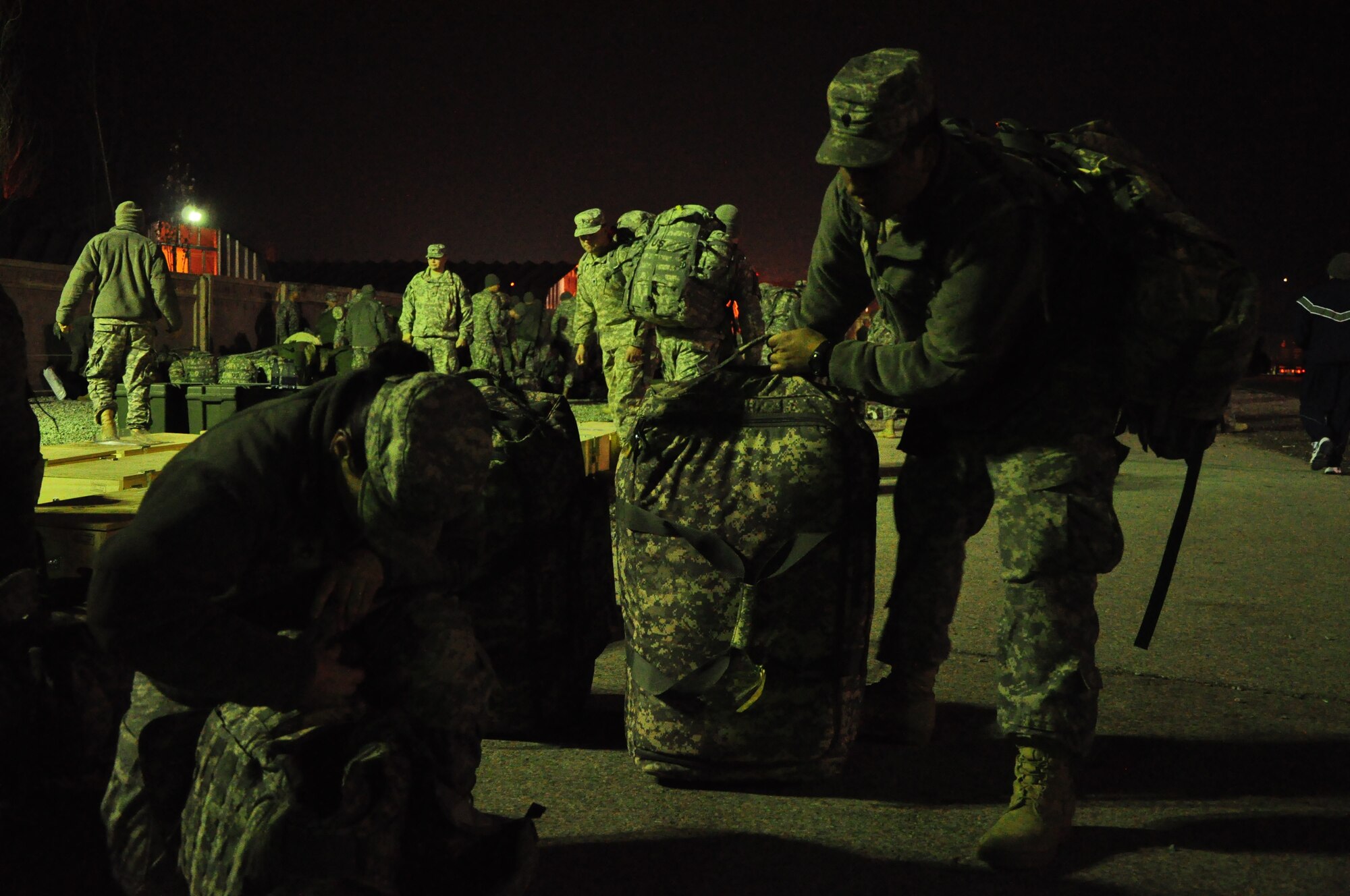 Army personnel gather their gear at night at the Transit Center at Manas. Scenes like this are a regular occurrence for the 24-hour, seven-day-a-week, operation at the Center supporting movement of personnel into and out of Afghanistan in support of Operation Enduring Freedom. Onward Movement of personnel is one of four mission pillars of the Center. The other three are Airlift, Air Refueling and Humanitarian Assistance. (U.S. Air Force photo/Master Sgt. Daniel Nathaniel III)