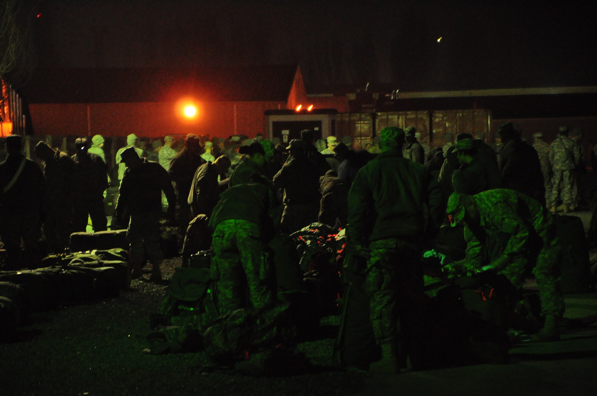 Army personnel gather their gear at night at the Transit Center at Manas. Scenes like this are a regular occurrence for the 24-hour, seven-day-a-week operation at the Center supporting movement of personnel into and out of Afghanistan in support of Operation Enduring Freedom. Onward Movement of personnel is one of four mission pillars of the Center. The other three are Airlift, Air Refueling and Humanitarian Assistance. (U.S. Air Force photo/Master Sgt. Daniel Nathaniel III)