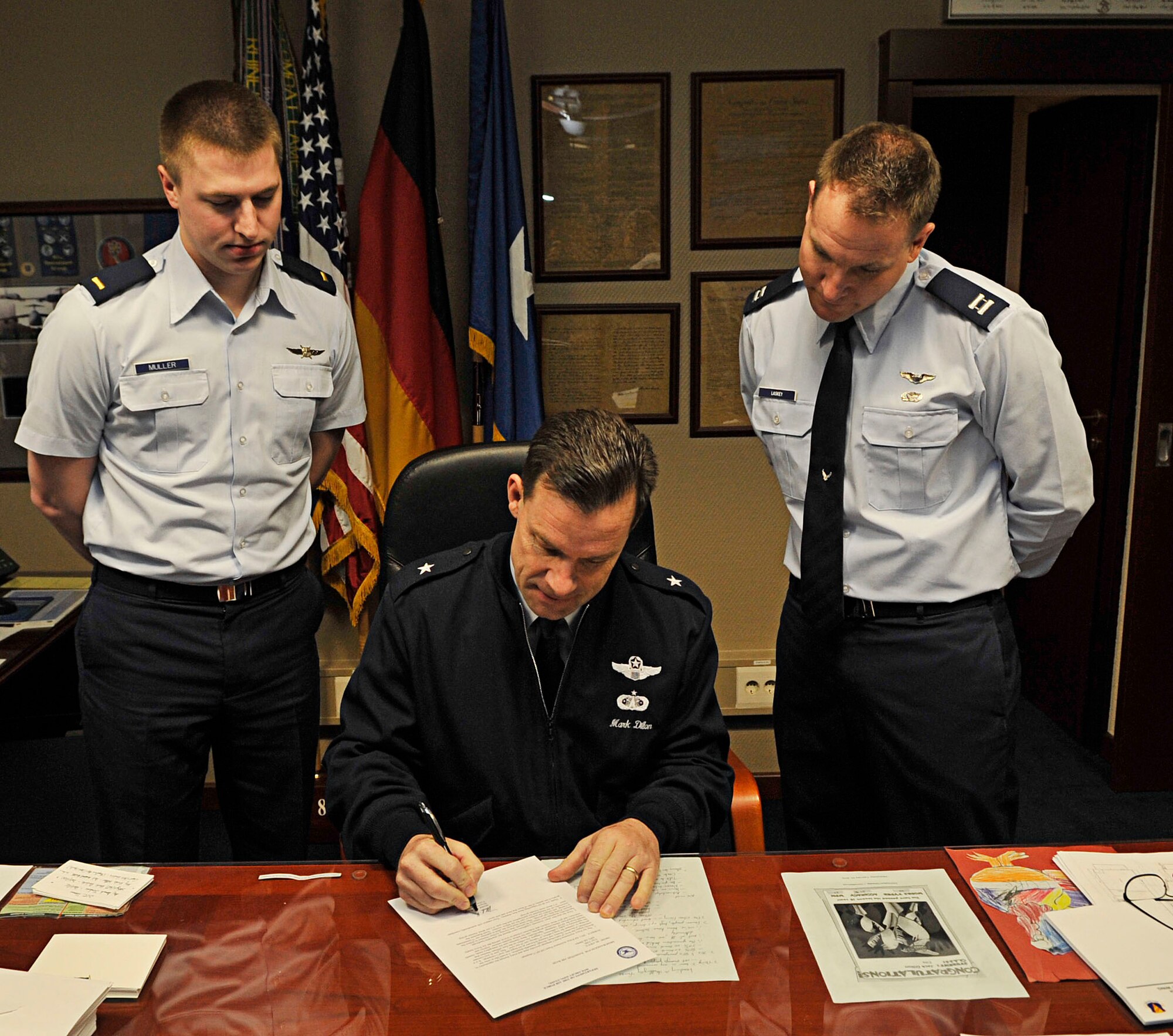U.S. Air Force Brig. Gen. Mark Dillon, 86th Airlift Wing commander, signs the Air Force Assistance Fund contribution form, while 2nd Lt. Mark Muller, 86th Communications Squadron and Capt. Donavan Laskey, 37th Airlift Squadron, observe, Ramstein Air Base, Germany, Feb. 7, 2011. The AFAF provides each and every Airman the opportunity to directly impact the lives of individuals through charitable donations. (U.S. Air Force photo by Airman 1st Class Desiree Esposito)