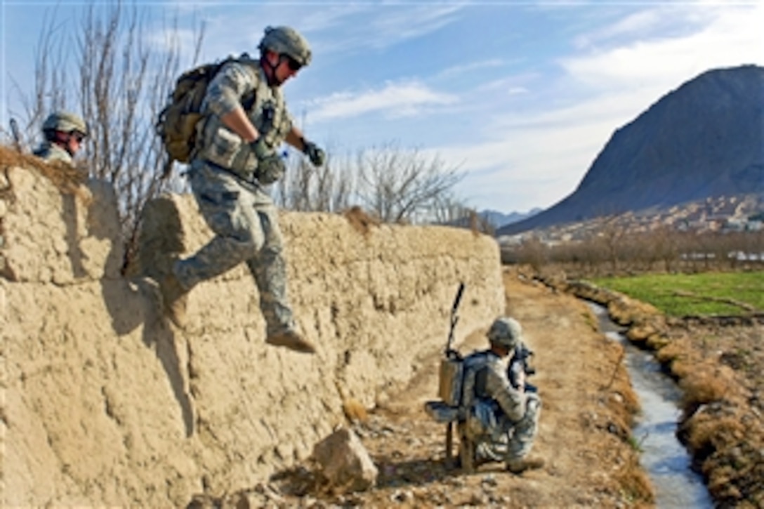U.S. Army Pfc. Andrew Ballard jumps from a mud wall while his squad provides security during a foot patrol in the Arghandab district, Afghanistan, on Jan. 31, 2011.  Ballard, assigned to the 4th Infantry Division's Company C, 1st Battalion, 66th Armored Regiment, 1st Brigade Combat Team, is conducting the foot patrol to search orchards throughout the district and interact with residents.  