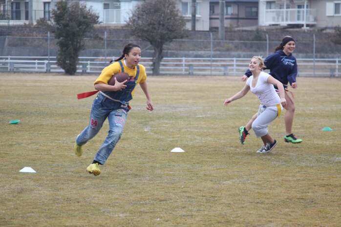 Bre’Onna Ray, a senior on the winning Powderpuff team, runs from members of the sophmore team as she attempts to score a touchdown.