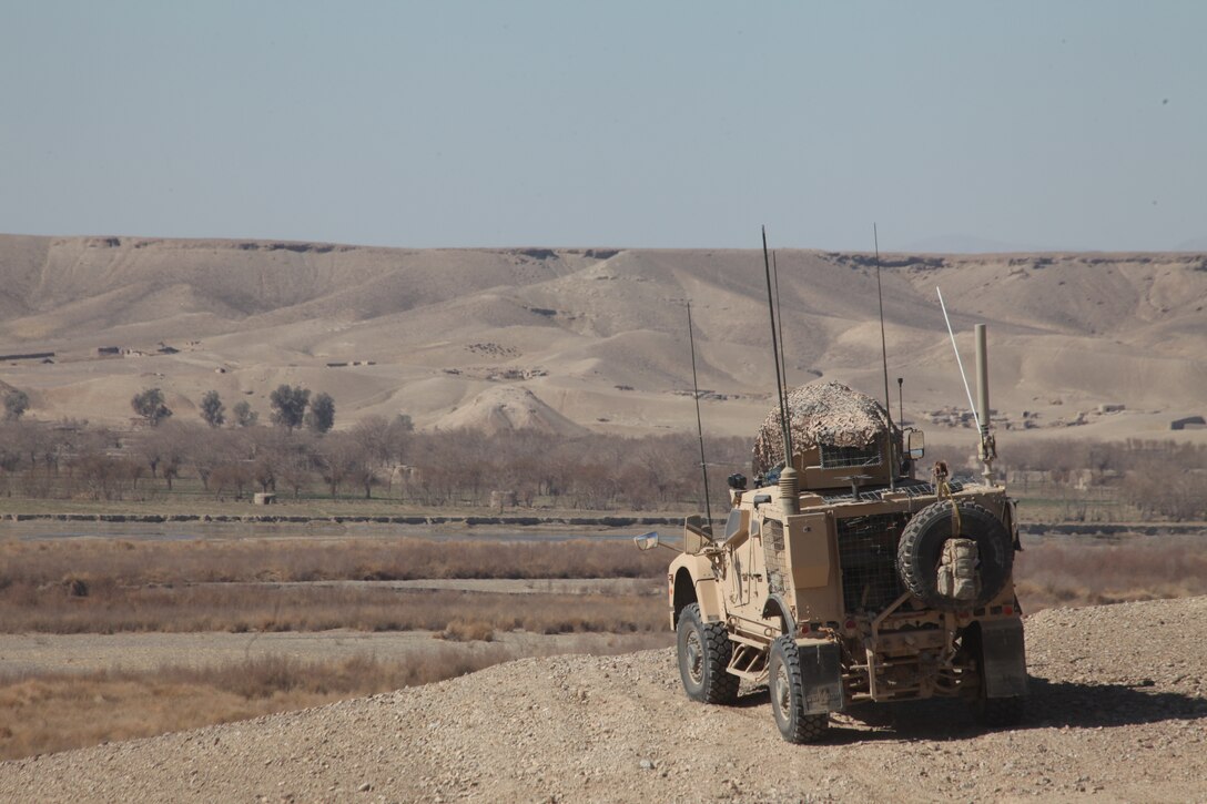 U.S. Marines with Company L, Battalion Landing Team 3/8, 26th Marine Expeditionary Unit, Regimental Combat Team 8, provide overwatch in a Mine Resistant Armor Protected All Terrain Vehicle (M-ATV) while U.S. Marines with 2nd Platoon, Company L patrol through the village of Chineh, Helmand province, Afghanistan, Feb. 8, 2011. Elements of the 26th Marine Expeditionary Unit deployed to Afghanistan to provide regional security in Helmand province in support of the International Security Assistance Force.