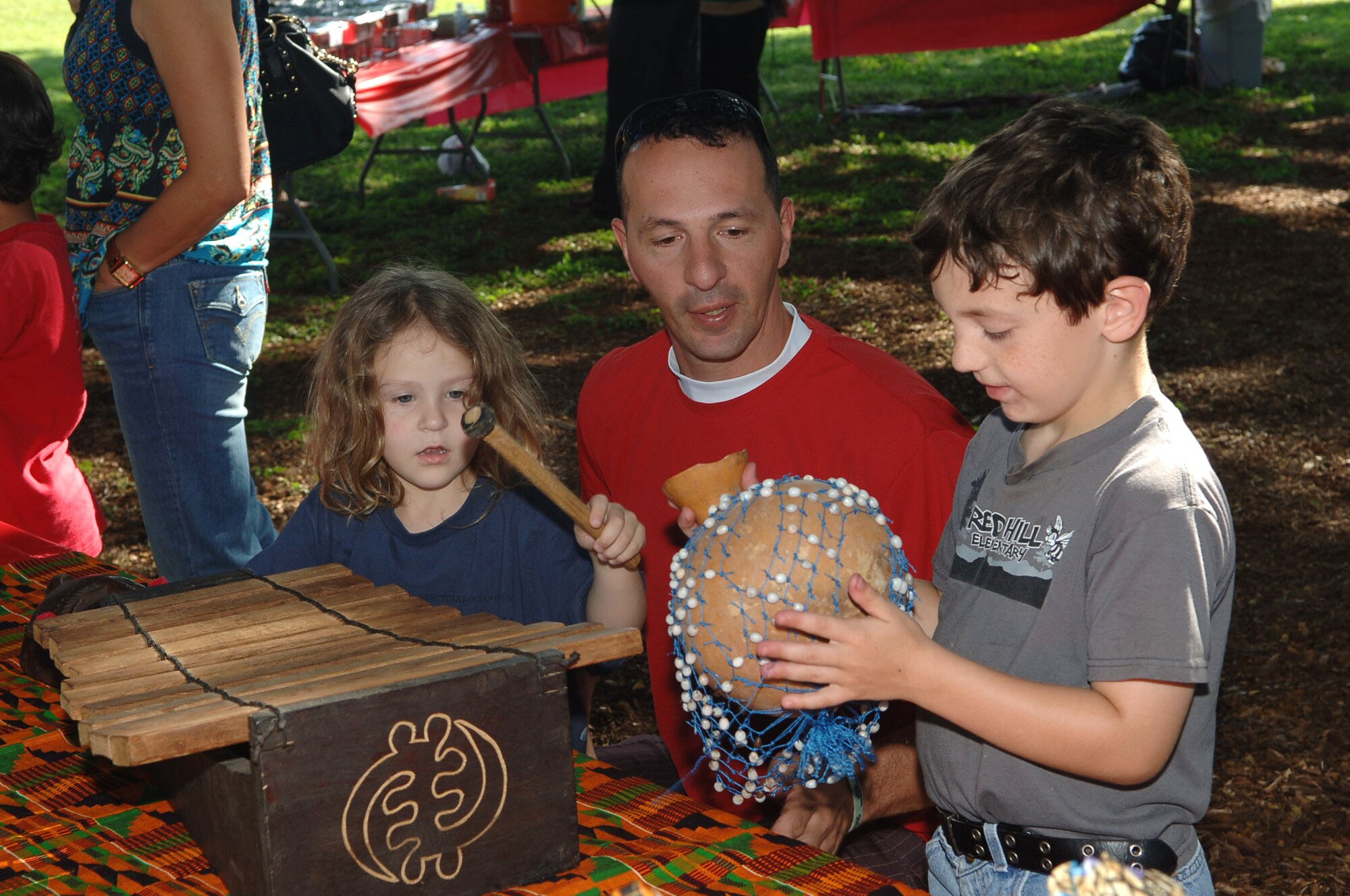 Army Master Sergeant Gerry Simard and his children Grace and Jeremy look at African crafts on display during a cultural showcase for African Americans in Hawaii on 4 Feb 2011 at the Hickam Community Center on Joint Base Pearl Harbor-Hickam, Hawaii. (U.S. Air Force photo/David D. Underwood, Jr.)