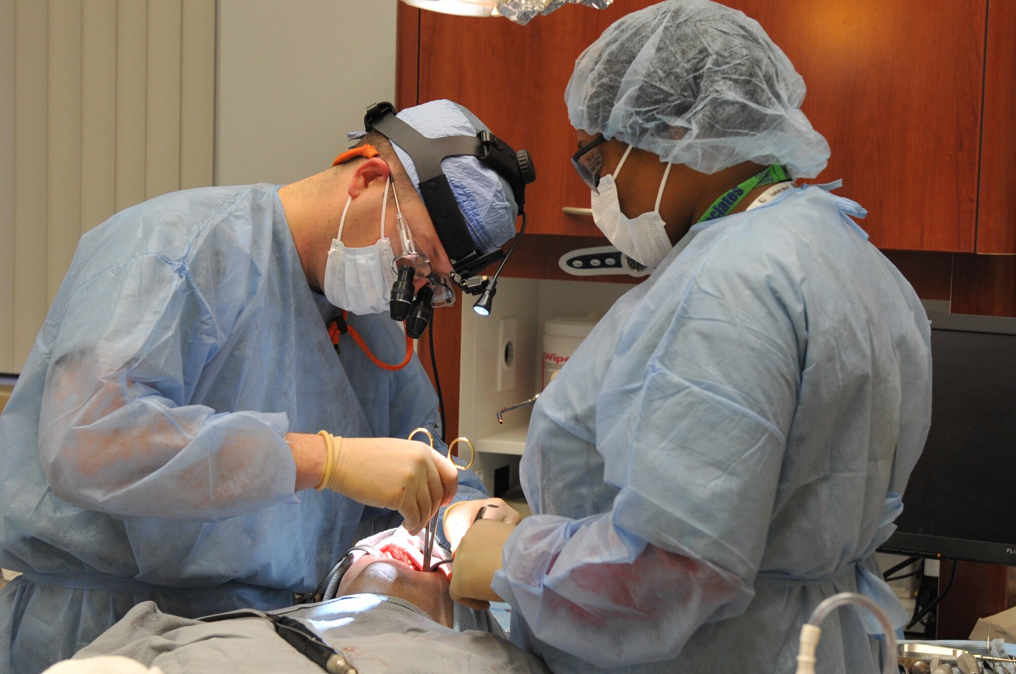 Capt. (Dr.) Christopher Jordan (left), a dentist with the 19th Aerospace Medical Squadron, extracts wisdom teeth from a patient with the help of Leah Robinson, a contract dental assistant, at Little Rock Air Force Base, Ark., Feb. 8, 2011. One of the services provided at the dental clinic is to remove wisdom teeth. The clinic extracted 542 wisdom teeth in 2010. (U.S. Air Force Photo by Airman 1st Class Rusty Frank)