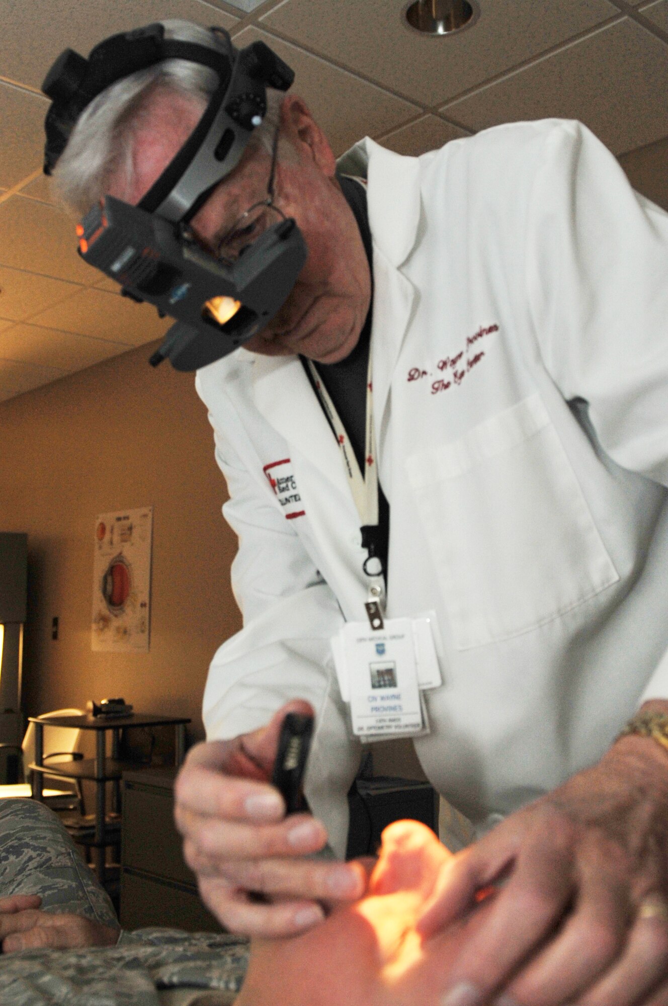 Dr. Wayne Provines, a Red Cross volunteer, performs a routine eye exam on a servicemember, at Little Rock Air Force Base, Ark., Feb.8, 2011. Military service members are required to get an eye exam once a year. (U.S. Air Force photo by Airman 1st Class Rusty Frank)