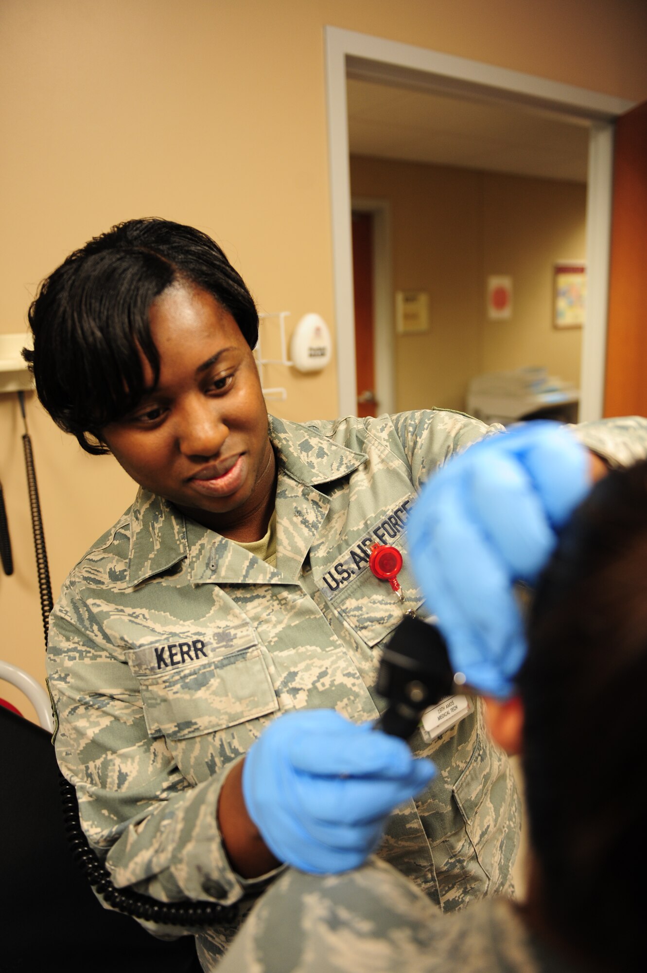 Senior Airman Shereece Kerr, a 19th Aerospace Medicine Squadron medical aerospace technician, examines a patient’s ear for possible irrigation Feb. 4, 2011, at Little Rock Air Force Base, Ark. The purpose of ear irrigation is to remove earwax obstructing the ear canal or to remove a foreign object lodged in the ear canal. (Photo by U.S. Air Force Senior Airman Jim Araos)