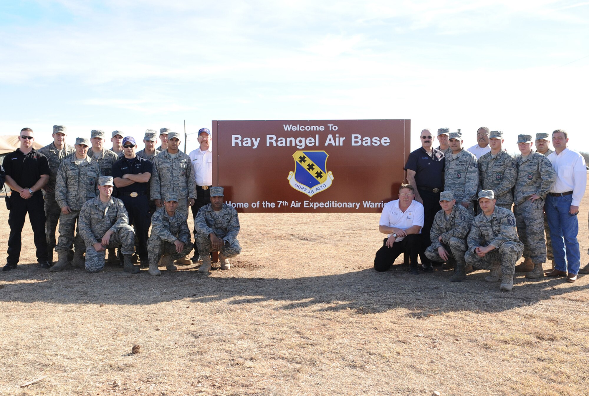 Firefighters pose  by a new sign honoring one of Dyess Air Force Base's fallen Airmen at the cantonment area Dec. 14, 2010, at Dyess AFB, Texas. The cantonment area, used to host exercises and training sessions, has been renamed in honor of Staff Sgt. Ray Rangel, a 7th Civil Engineer firefighter who lost his life Feb. 13, 2005, at the age of 29, while on a rescue mission in Balad, Iraq. (U.S Air Force photo/Airman 1st Class Shannon Hall)