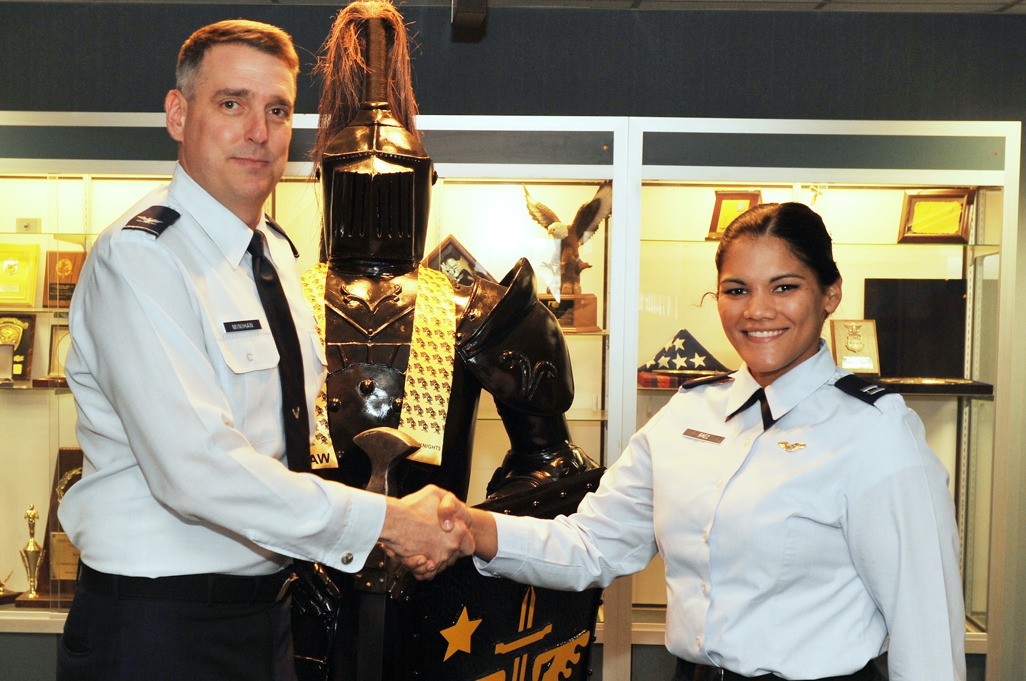 Col. Mike Minihan, 19th Airlift Wing commander, presents a coin Feb. 7, 2011, to Capt. Veronica Baez, 19th Airlift Wing Director of Staff executive officer, for her selection as the Combat Airlifter of the Week at Little Rock Air Force Base, Ark. As a founding member of Central Arkansas Women in Aviation International, Captain Baez helped to provide education and scholarship opportunities for young women in Arkansas. (U.S. Air Force photo by Airman 1st Class Rusty Frank)