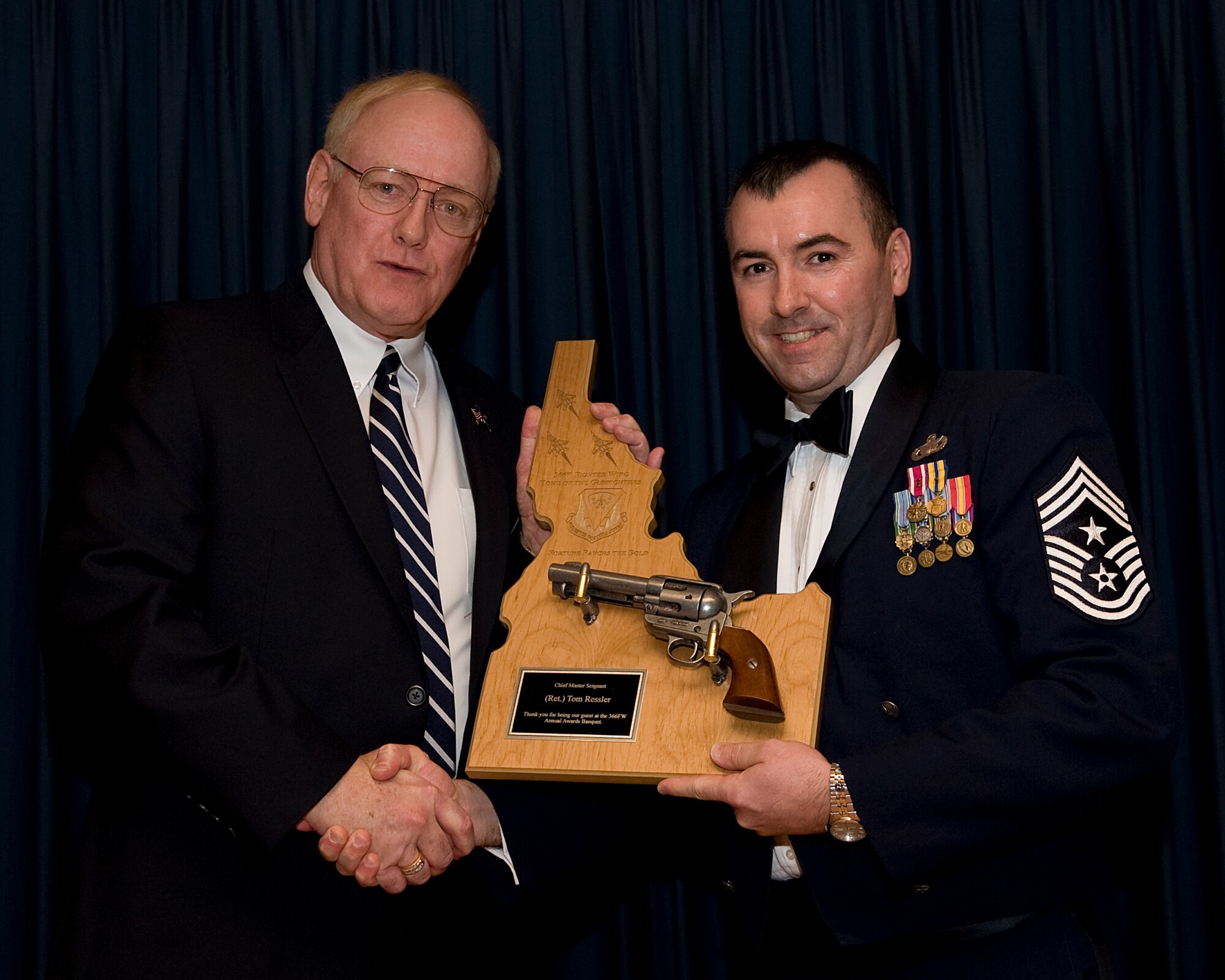 MOUNTAIN HOME AIR FORCE BASE, Idaho -- Chief Master Sgt. Ronald McCarthy, 366th Fighter Wing command chief, presents Chief Master Sgt. (retired) Tom Ressler, guest speaker, with a gift during the 2010 Annual Awards Ceremony here Feb. 4. The ceremony allowed 15 Airmen and civilians to be recognized for their accomplishments throughout 2010. (U.S. Air Force photo by Staff Sgt. Roy Lynch)