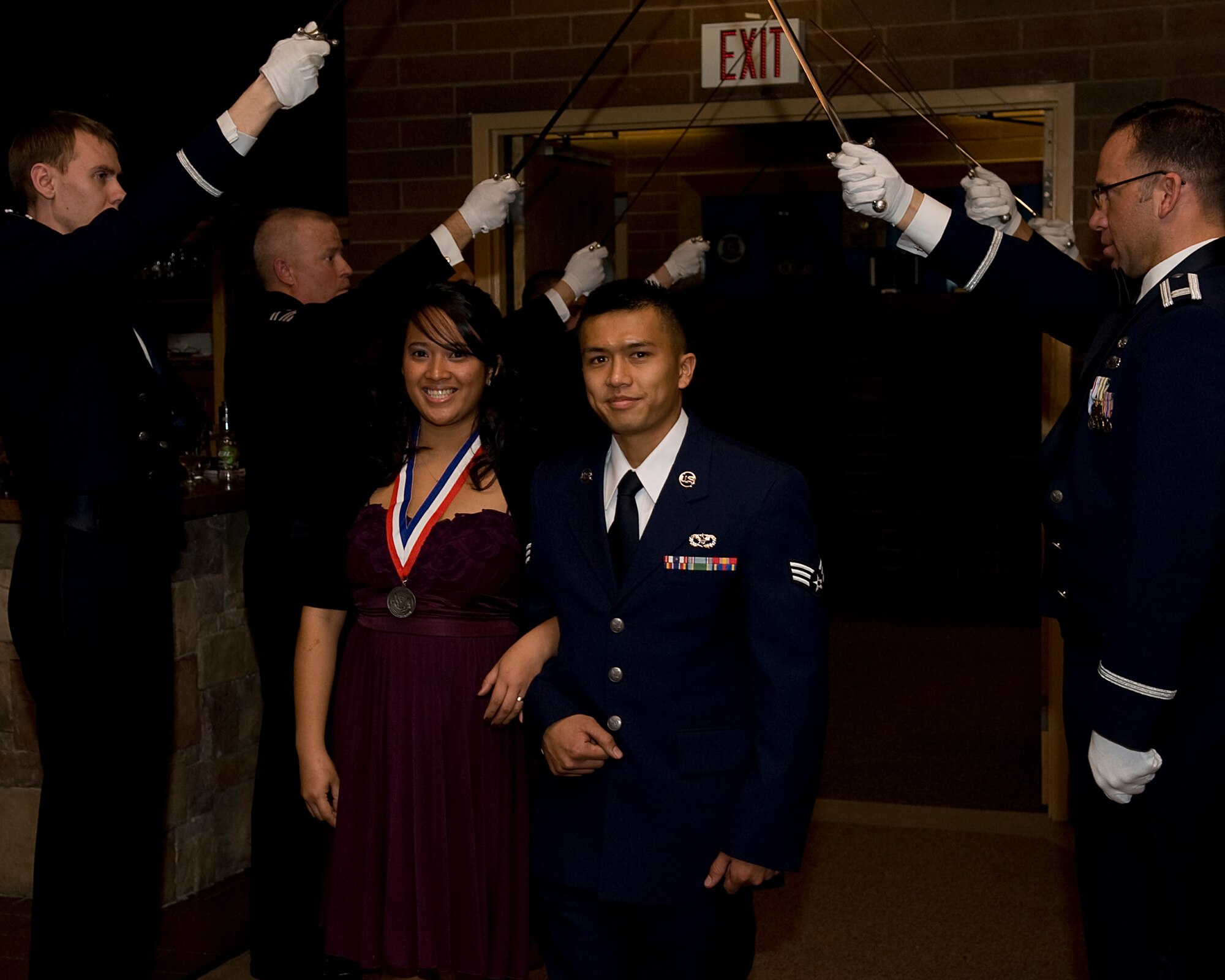 MOUNTAIN HOME AIR FORCE BASE, Idaho -- Senior Airman David Khinsavath, 366th Civil Engineer Squadron, escorts his wife Evan Khinsavath, winner of the Spouse Volunteer of the Year, through the saber team during the 2010 Annual Awards Ceremony here Feb. 4. The ceremony allowed 15 Airmen and civilians to be recognized for their accomplishments throughout 2010. (U.S. Air Force photo by Staff Sgt. Roy Lynch)