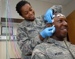 Staff Sgt. Vaniece Shorter, neurodiagnostics technician, 59th Medical Operations Squadron, applies electrodes to Senior Airman Christopher Morris's head before performing an electroencephalogram on Dec. 9, 2010 at Wilford Hall Medical Center, Lackland Air Force Base, Texas. The majority of the WHMC Neurology Clinic services will relocate to Brooke Army Medical Center, Ft. Sam Houston, Texas, in March 2011. (U.S. Air Force Photo by Staff Sgt. Josie Walck)
