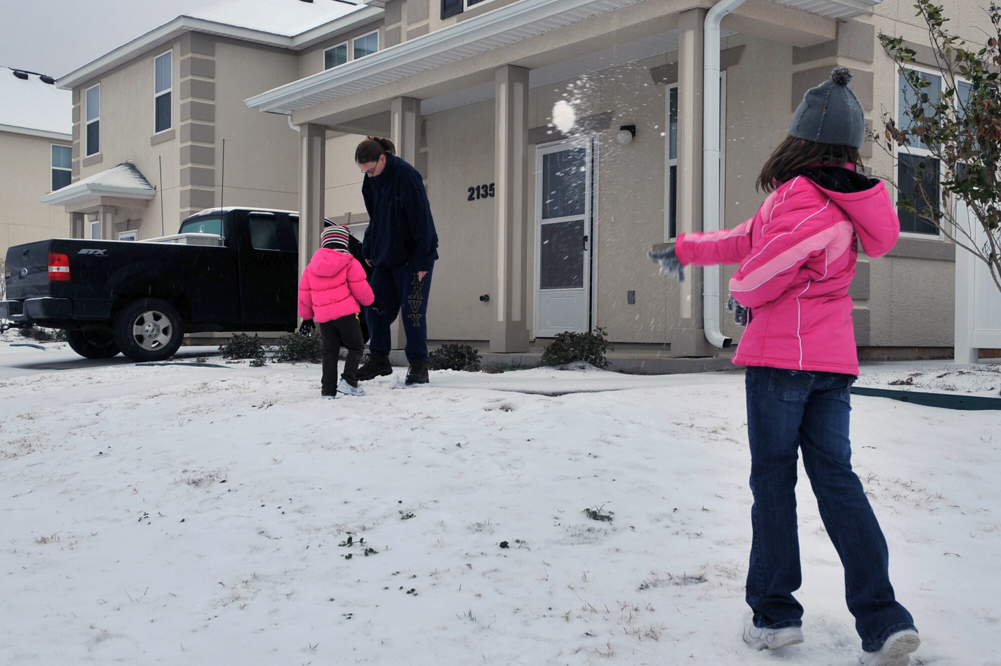 Rebekkah Counha, 10, throws a snow ball at her sister Jacquelyn, 5, and mother, U.S. Navy Petty Officer 2nd Class Jennifer Counha, Naval Mobile Construction Battalion 28, in front of their home on Barksdale Air Force Base, La., Feb. 4. The Counha's enjoy their snow day by having snowball fights and making snow angels. (U.S. Air Force photo/Airman 1st Class Micaiah Anthony)(Released)