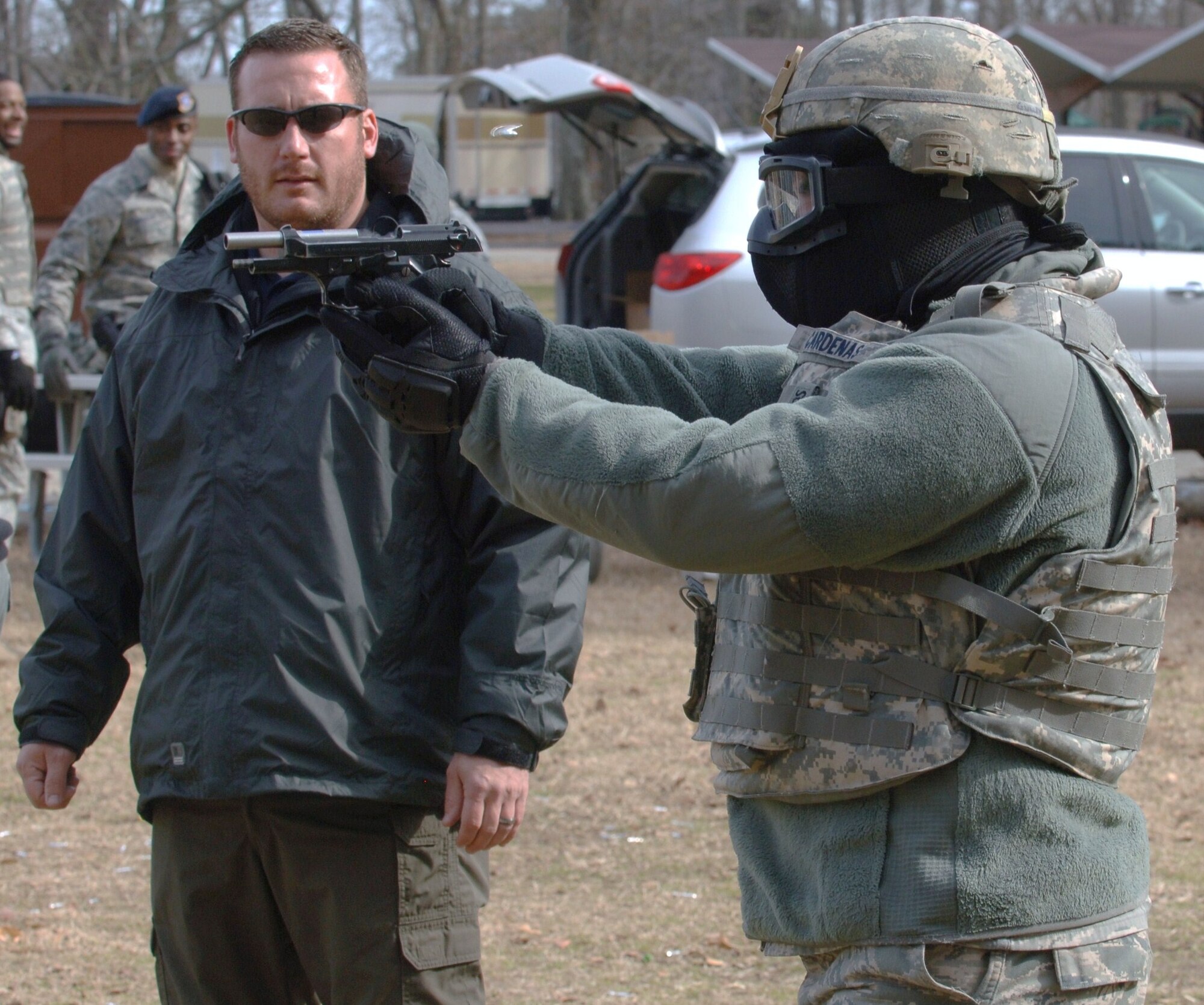 LANGLEY AIR FORCE BASE, Va. -- Eric Seto (left), Ultimate Training Munitions training manager, observes as Airman Juan Cardenas, 633d Security Forces Squadron patrolman, fires a Beretta 9 mm pistol equipped with UTM ammunition during UTM ballistics training at Bethel Park Feb. 3. UTM ammunition provides a more realistic and flexible approach to marksmanship training, as it can be used with assault rifles and handguns. (U.S. Air Force photo/Airman 1st Class Jason J. Brown) (RELEASED)